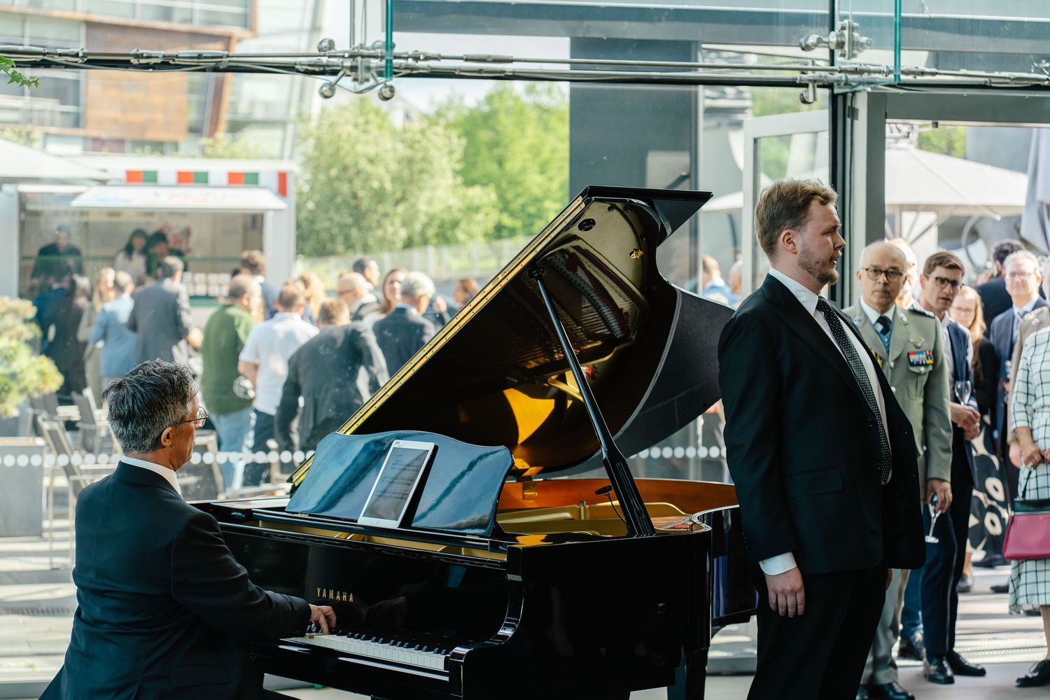 Pianist performing on grand piano at outdoor National Day of Italy reception.
