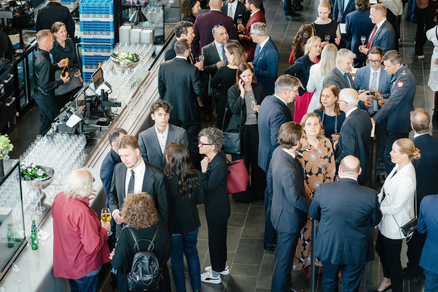 Guests networking at National Day of Italy reception in modern venue.