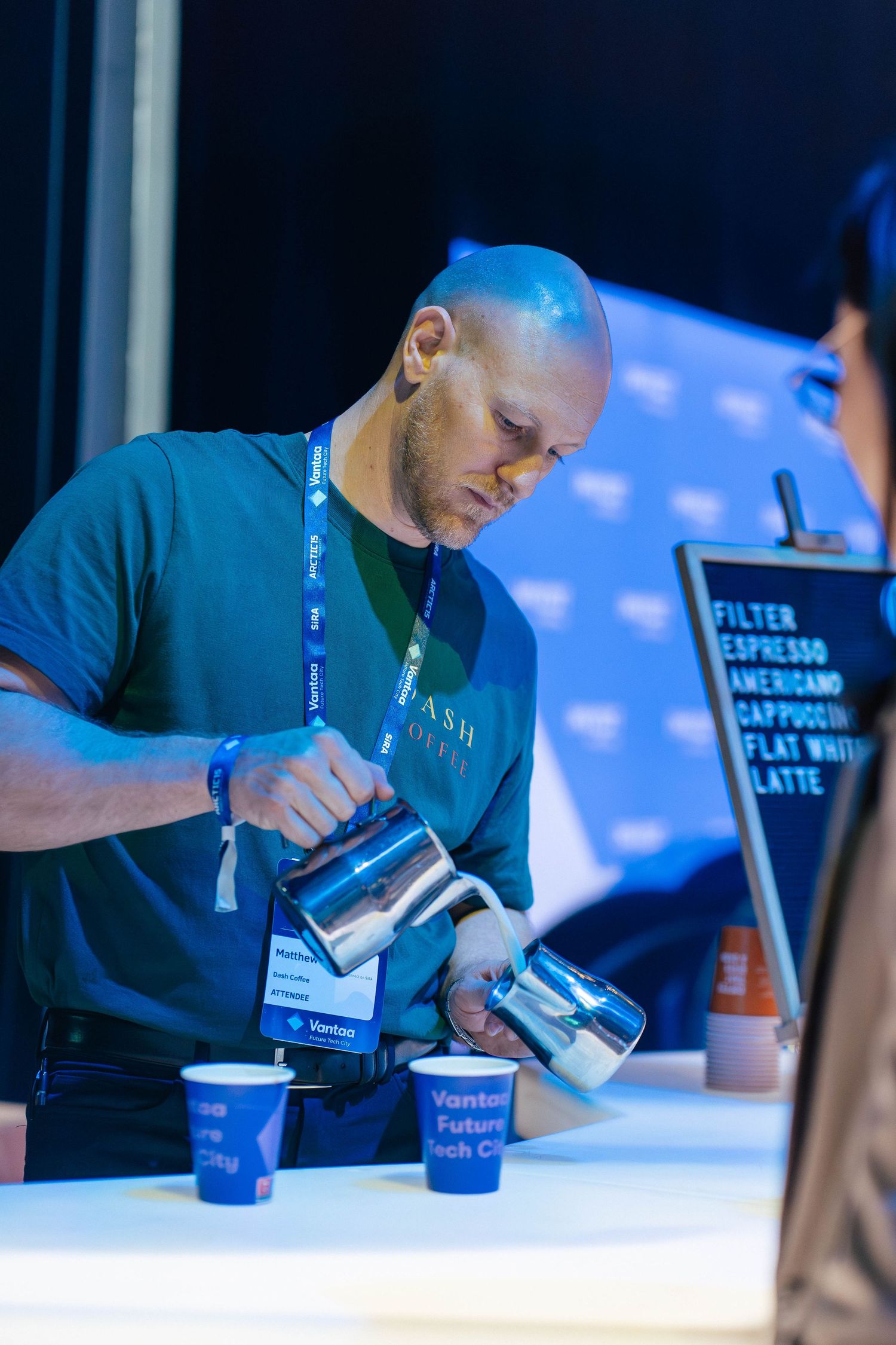 Barista pouring latte art at Vantaa Future Tech City Café event.