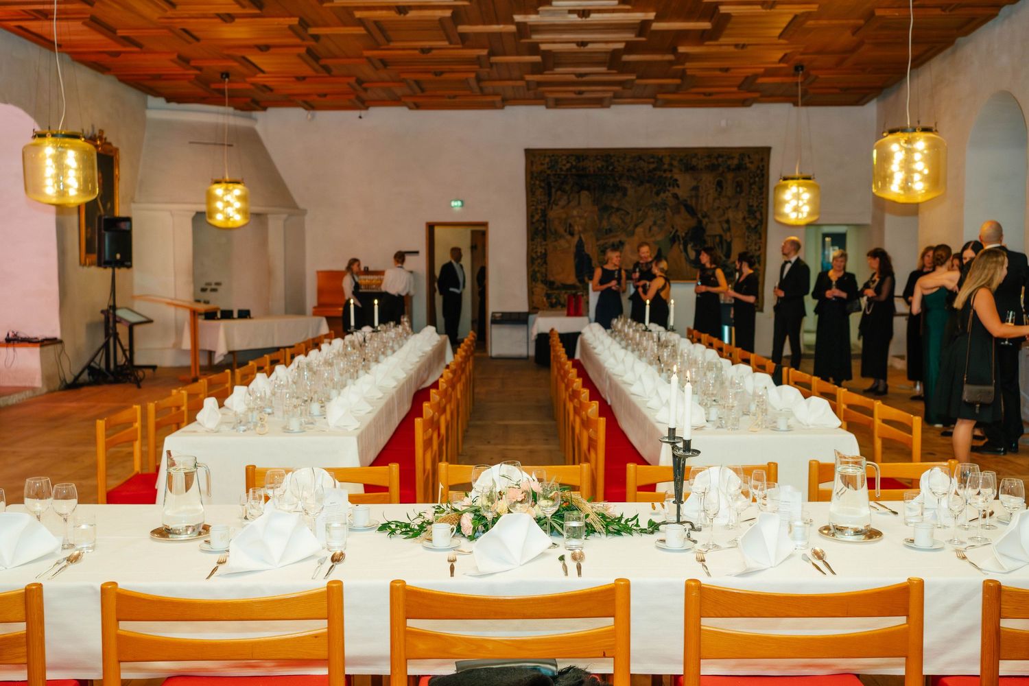Elegant banquet hall with long white-clothed tables set for a formal dinner reception.