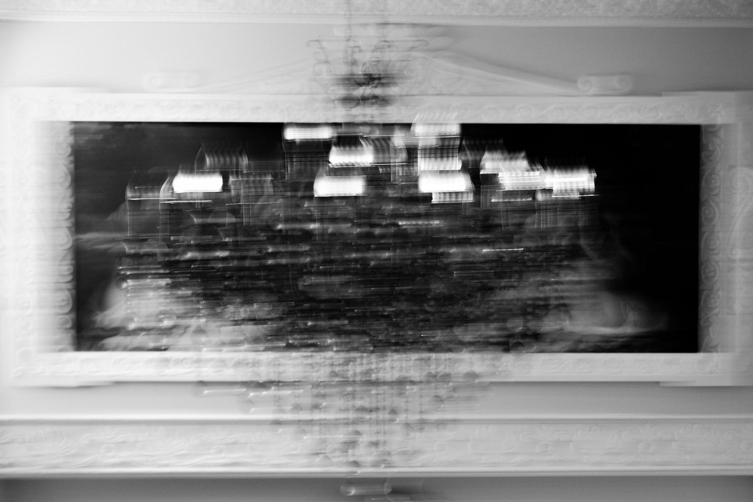Abstract black and white motion blur photograph of a building facade displayed as wall art.