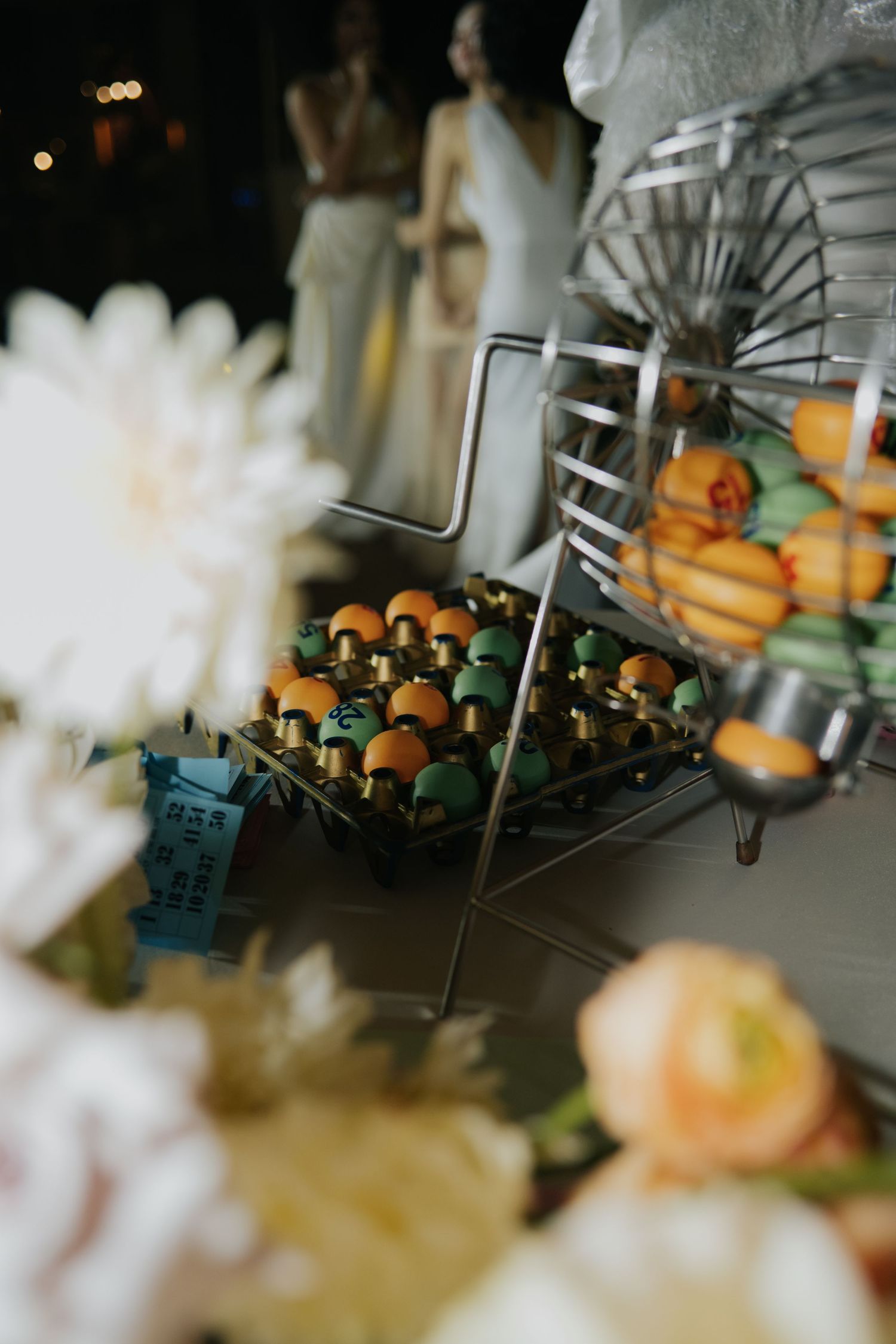 Elegant wedding dessert display featuring colorful macarons and fresh fruit arranged on metallic stands with floral decorations.