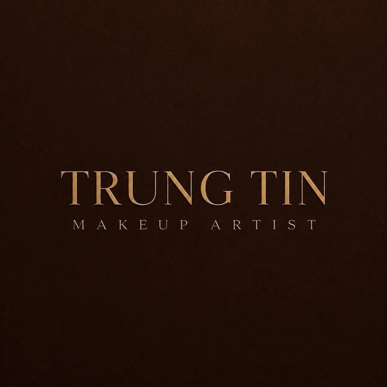 Gold text logo for Trung Tin Makeup Artist on a dark brown background.