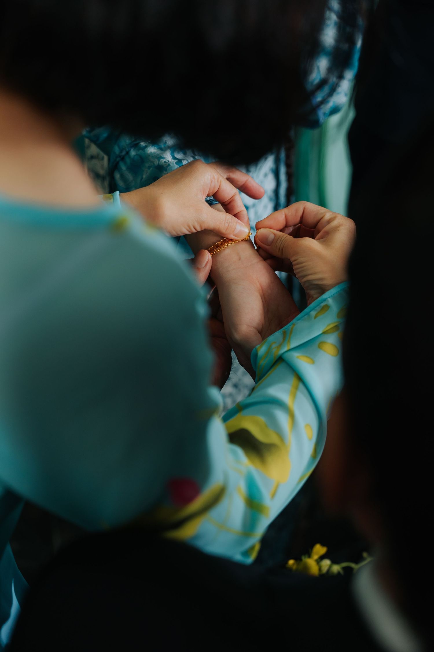 Close-up of hands exchanging a gold wedding ring during an intimate wedding ceremony ritual.
