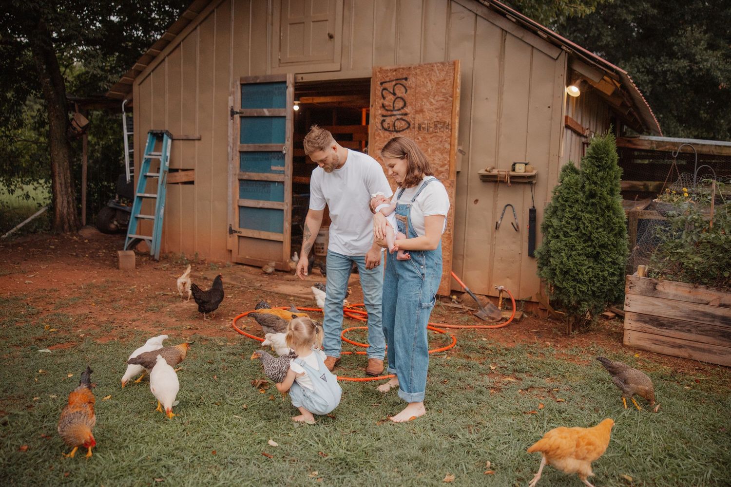 Family feeding chickens and ducks outside a rustic wooden coop on a farm.