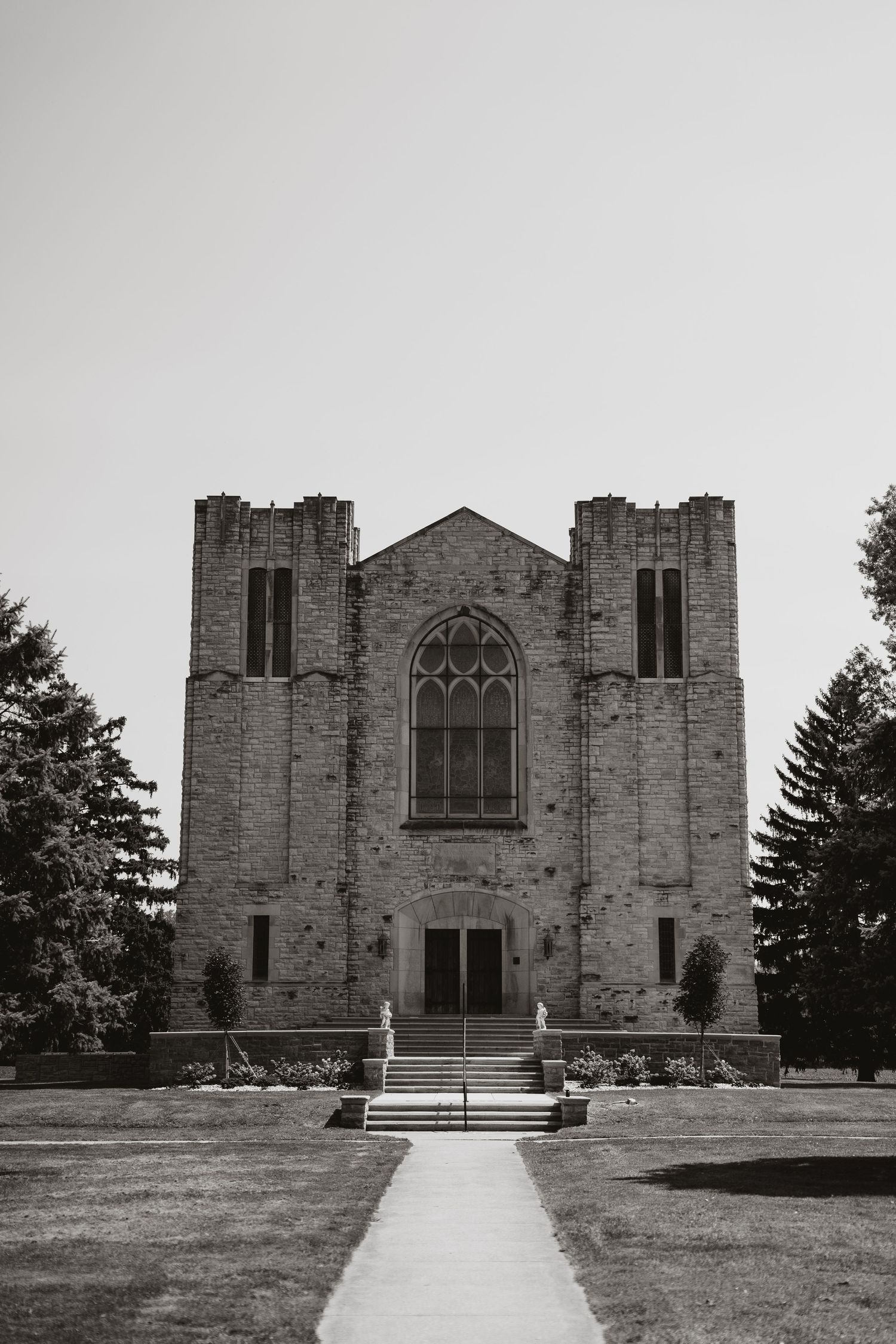 Gothic stone church exterior with twin towers and arched entrance in black and white. Tiffin, Ohio Wedding Venue