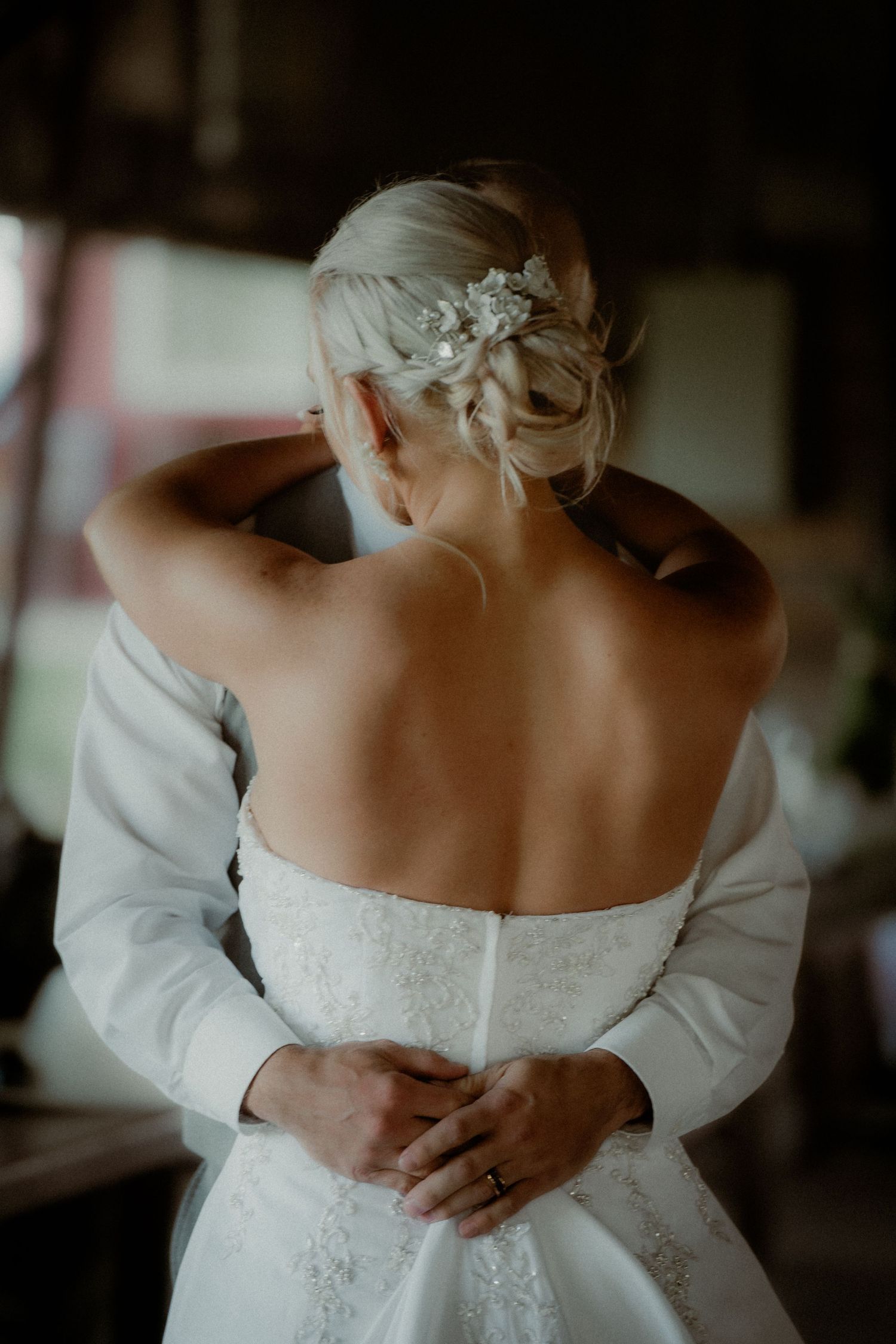An intimate getting ready moment showing the back detail of a white wedding gown.  Clyde, Ohio copper whale winery