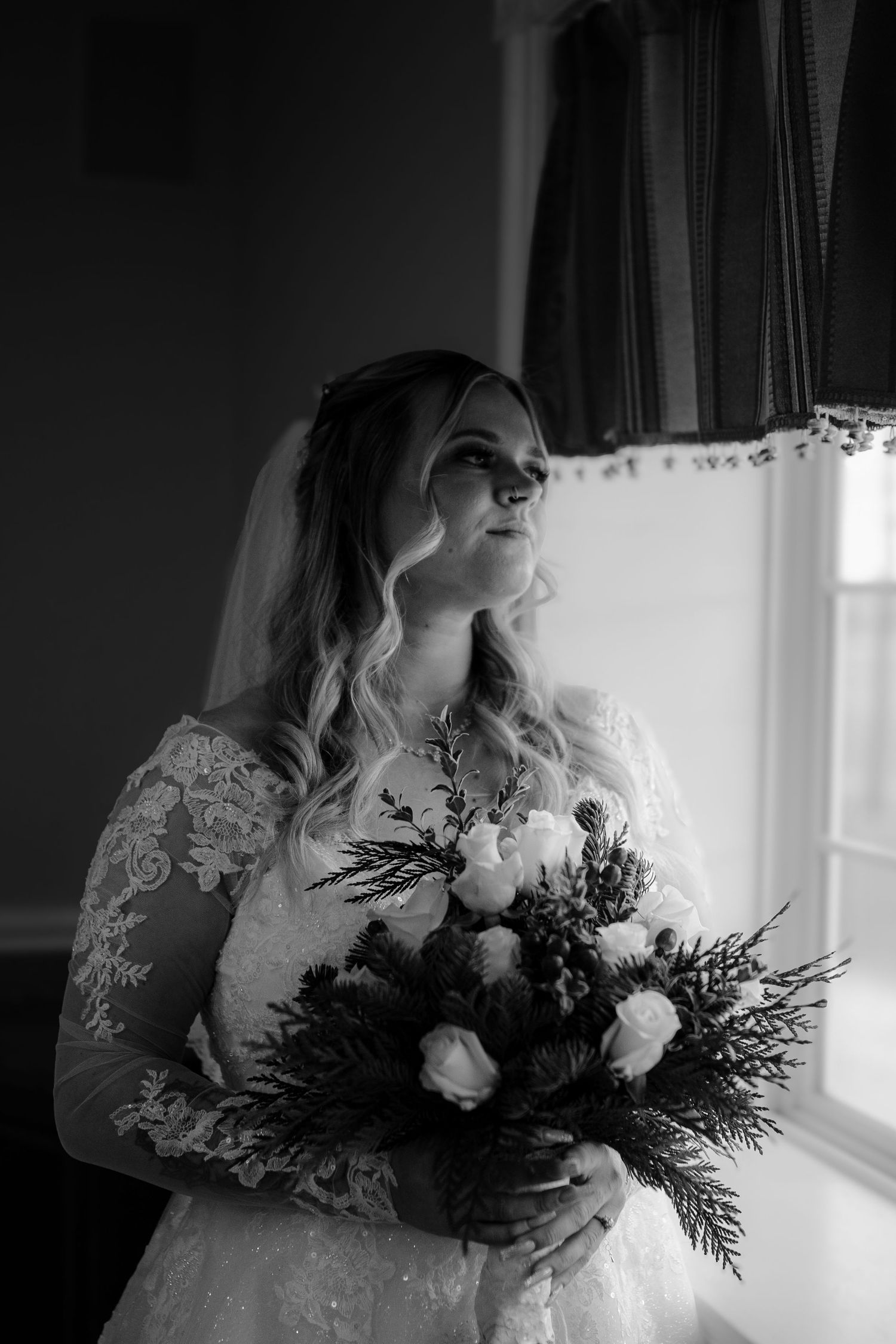 A winter bridal bouquet with white roses and evergreen branches in dramatic black and white. Rising Sun Ohio
