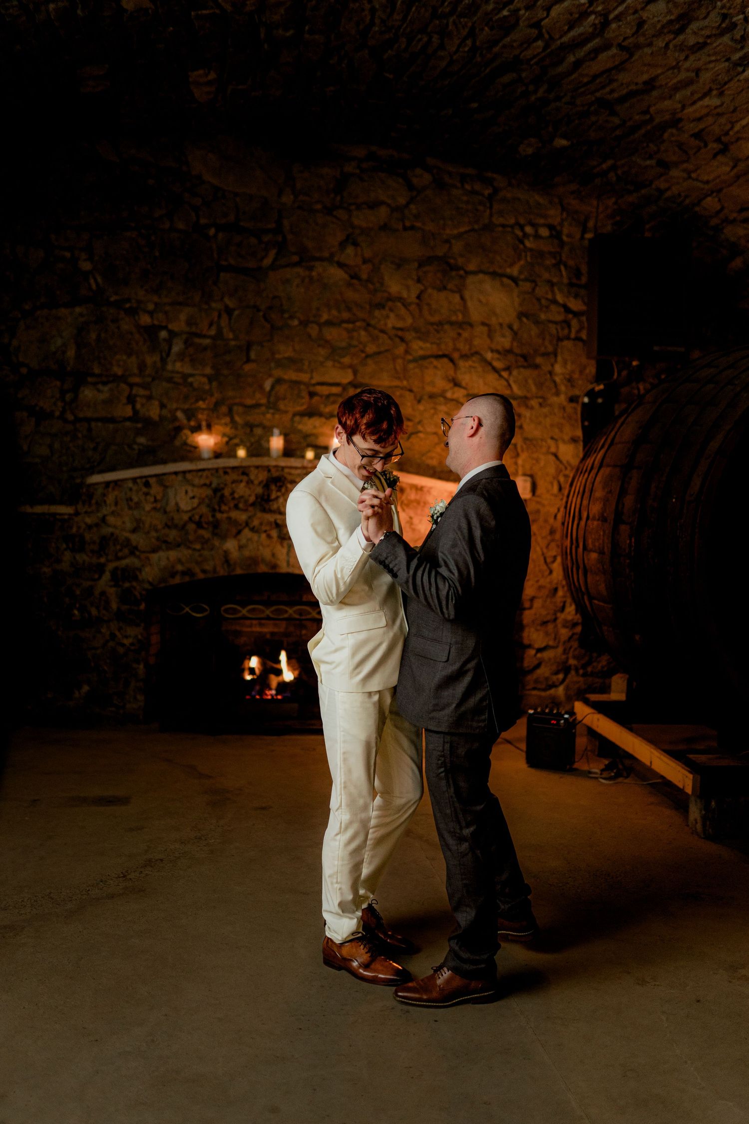 A couple dances together in a dimly lit stone cellar with candlelight. Gideon Owen Winery ohio wine cellar
