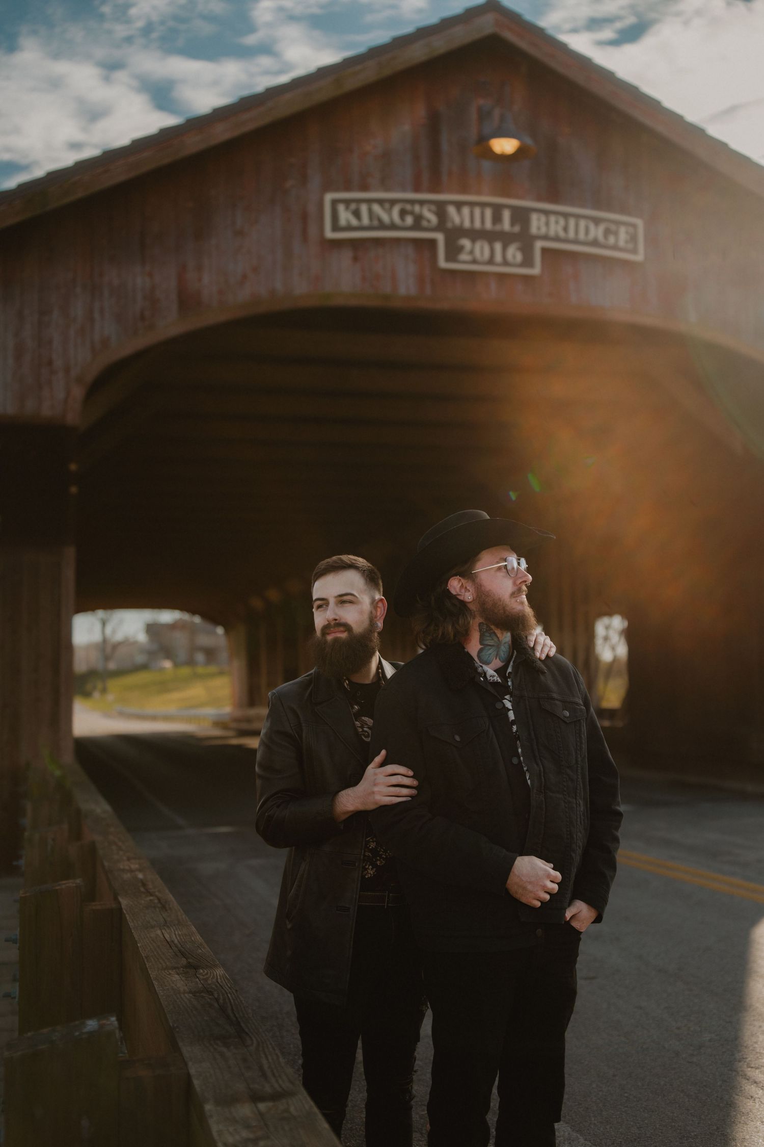 Two people share drinks and conversation near a covered bridge at dusk. Marion Ohio