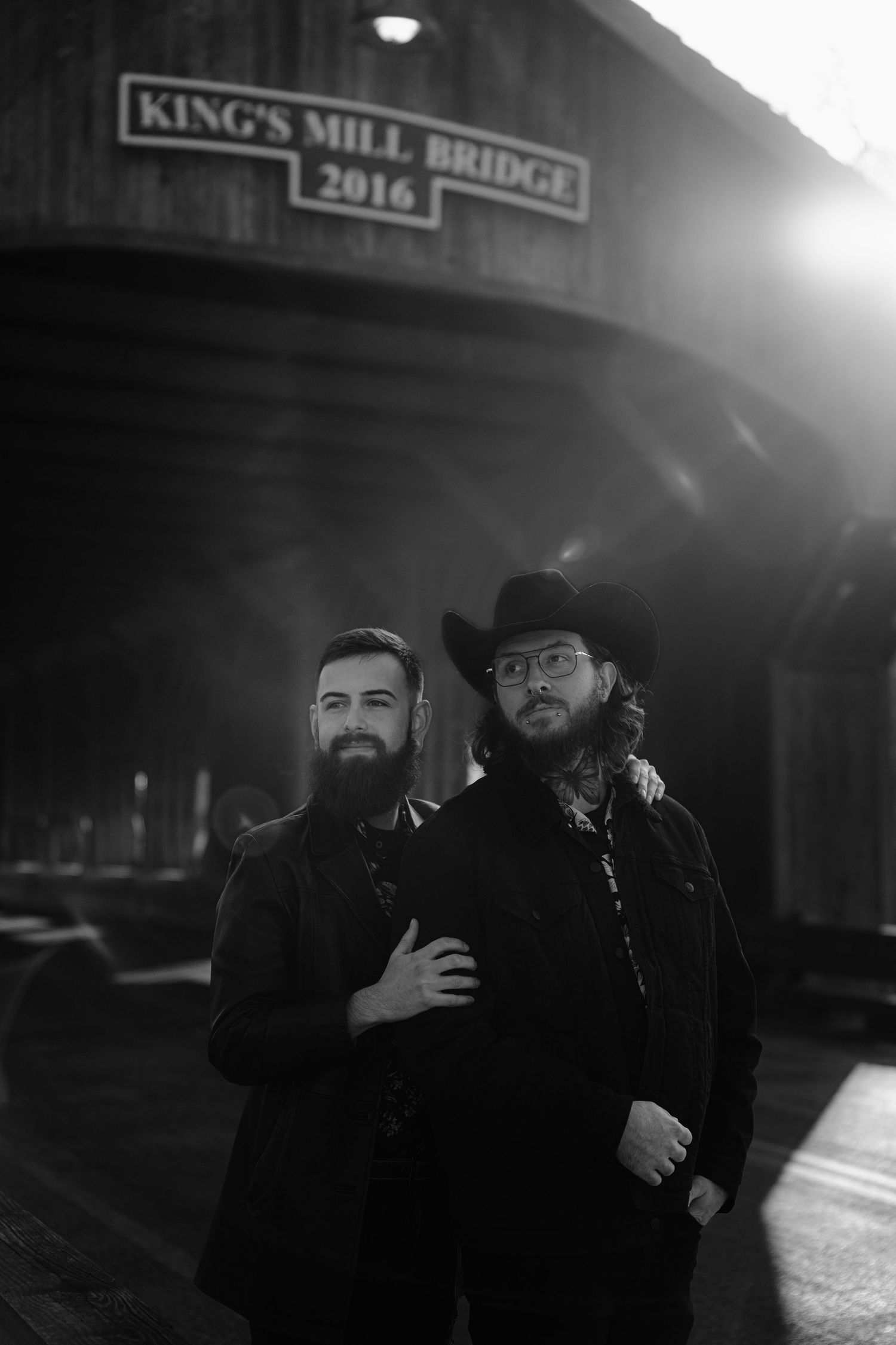 Moody black and white portrait of two figures at King's Mill Bridge with dramatic sunlight. Marion, Ohio
