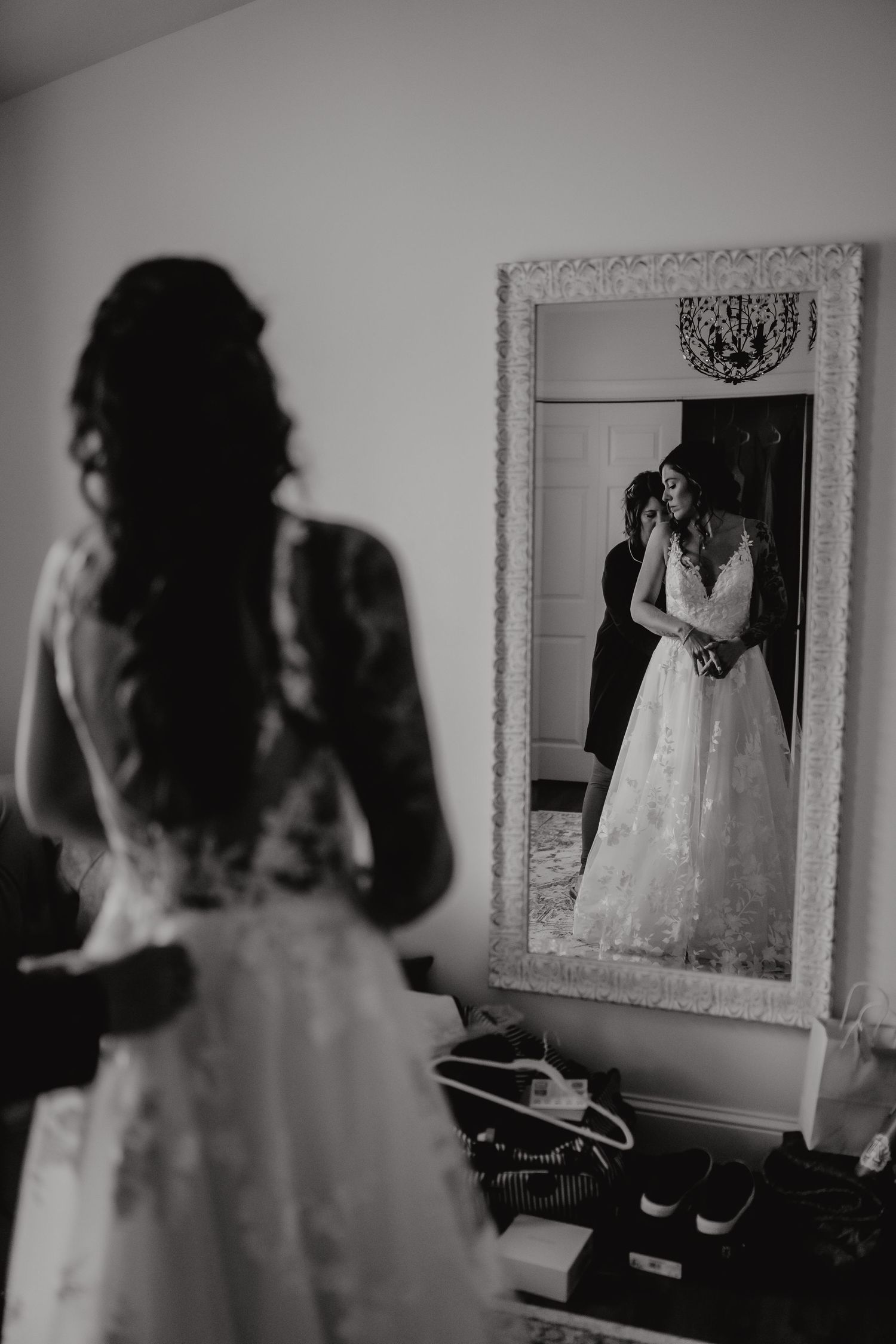 A series of black and white bridal portraits showing the back of a wedding dress in front of an ornate mirror. Delta, Ohio wedding venue