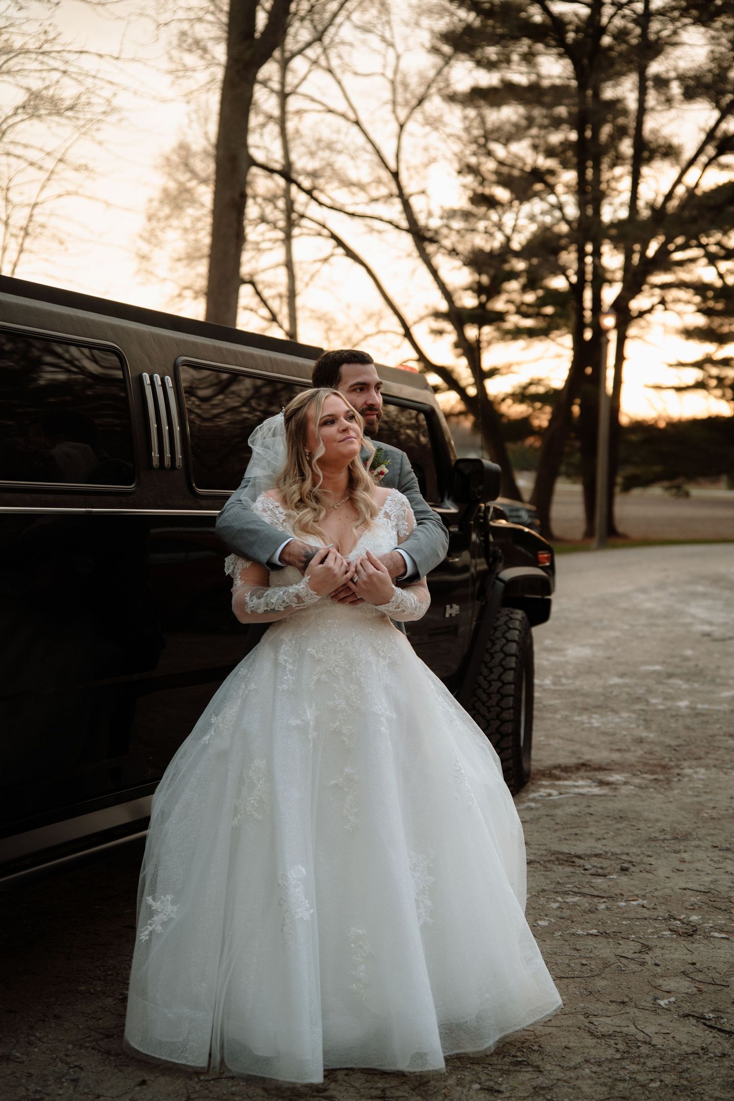 A beautiful wedding dress with full tulle skirt photographed at sunset near a vintage car.  Rising Sun Ohio