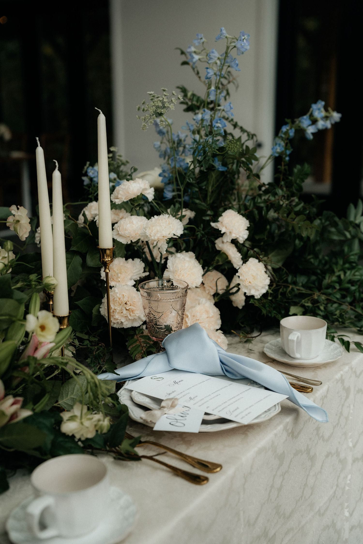 Elegant table setting with white candles, flowers and place settings. Wooster Ohio The Wellspring Wedding Venue