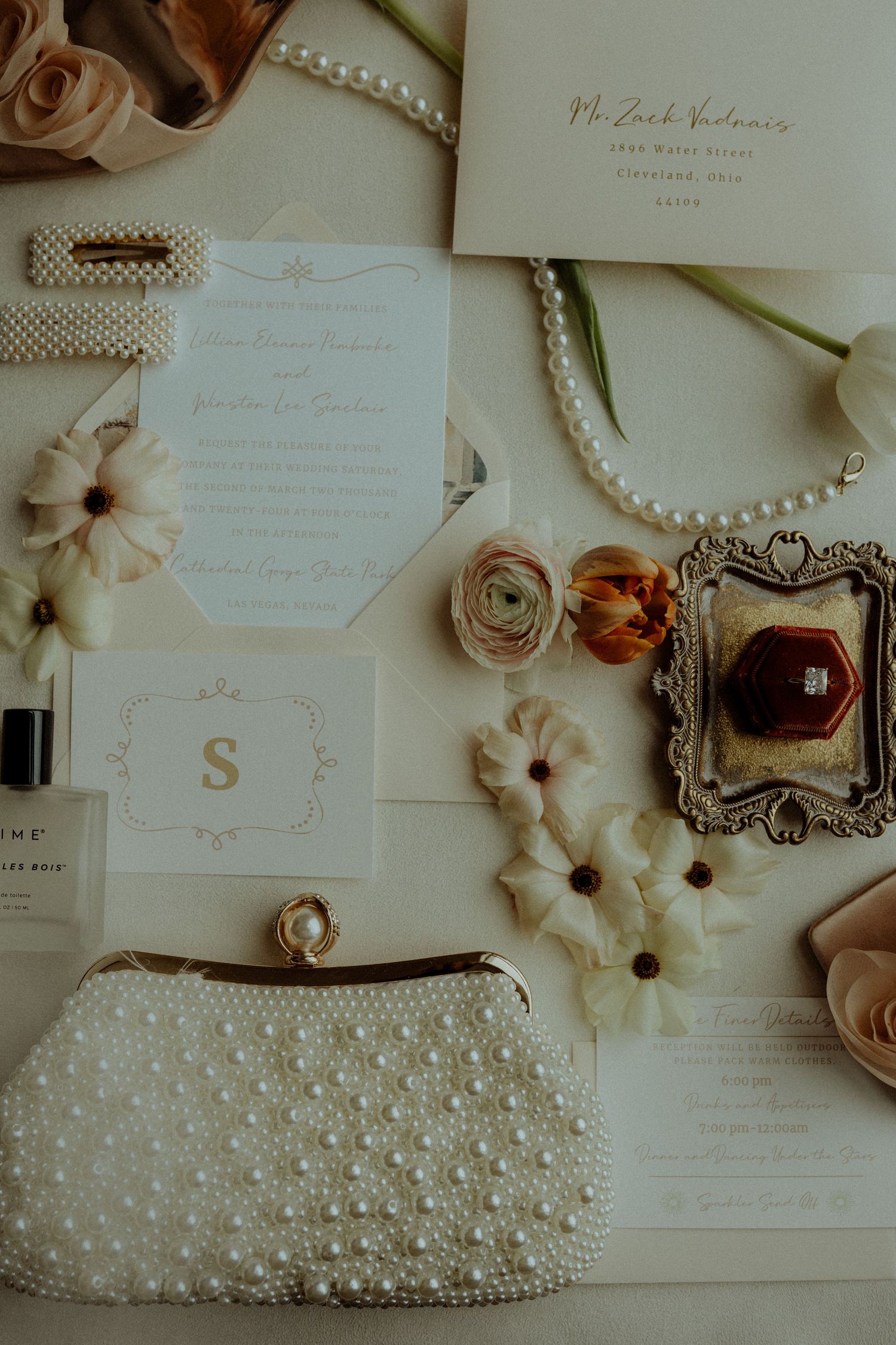 Wedding stationery flat lay with pearl clutch and delicate floral details. Wooster Ohio The Wellspring Wedding Venue