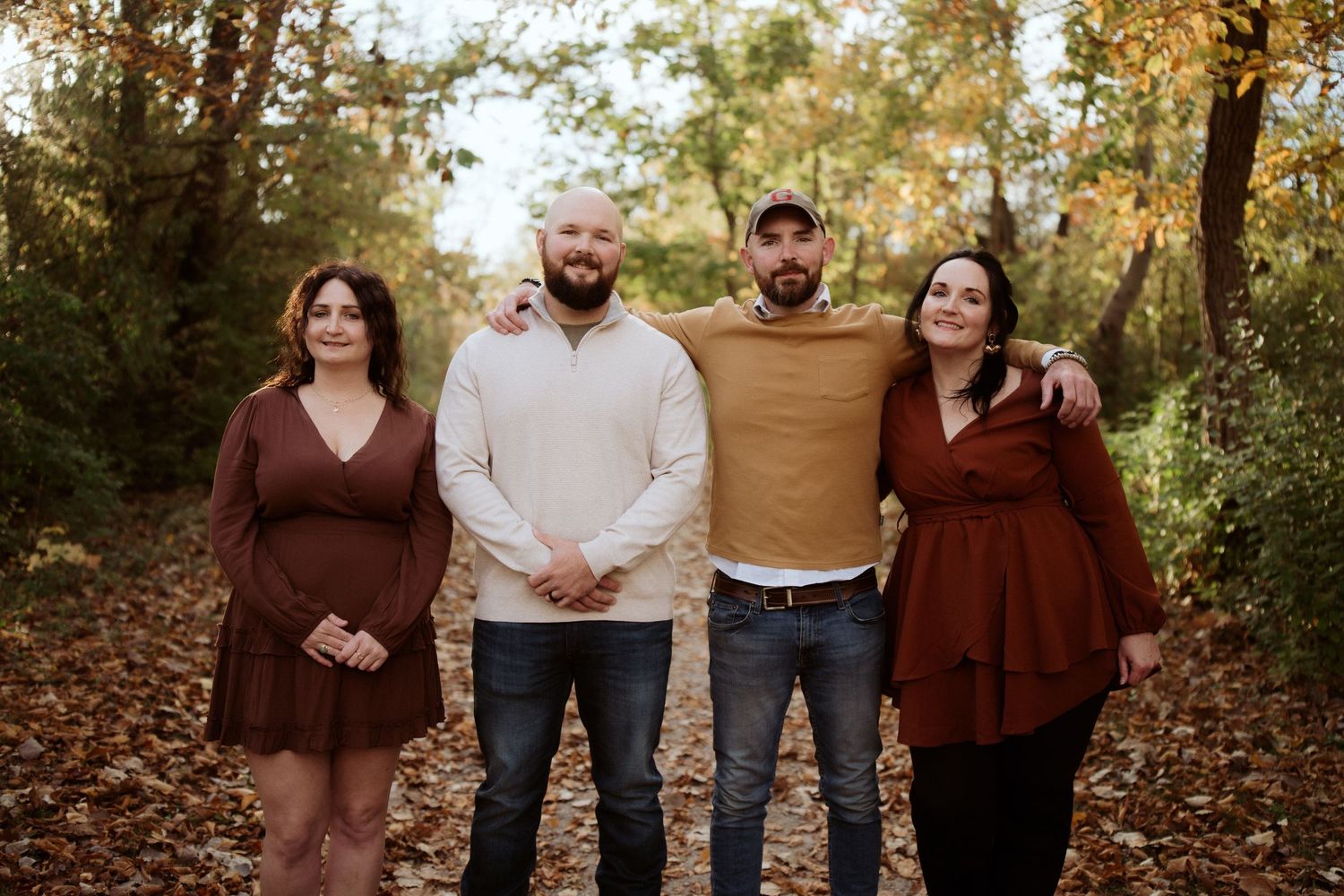 Group wearing coordinated brown and neutral tones pose together in autumn foliage. Castalia Quarry, Ohio