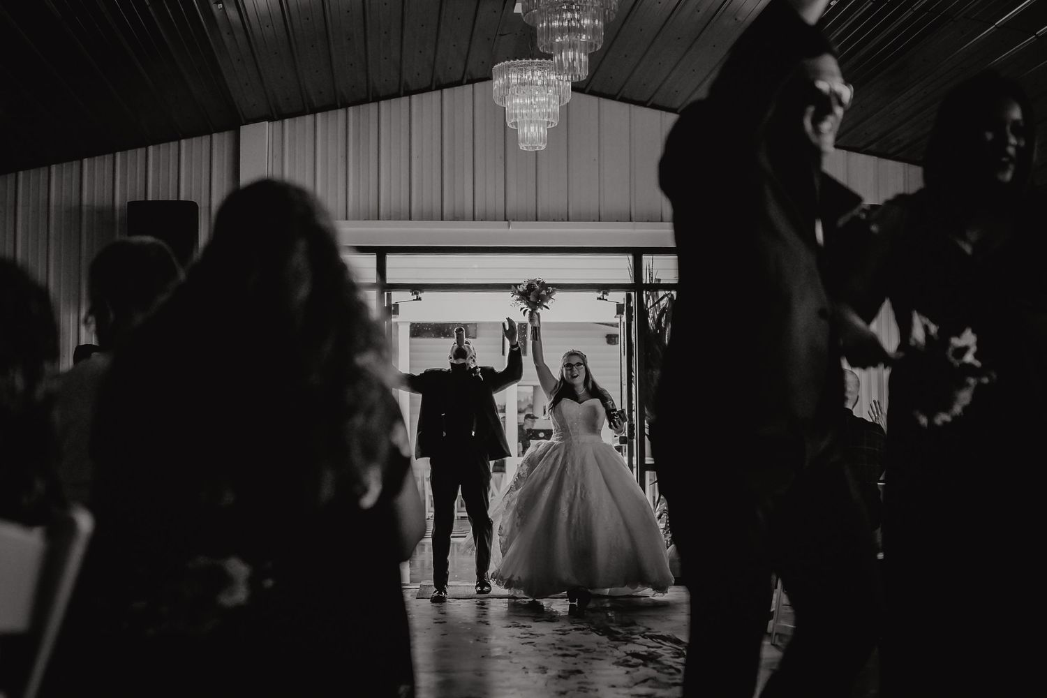 Black and white dance floor scene with elegant silhouettes and chandeliers creating a romantic atmosphere. Tiffin, Ohio Wedding Venue