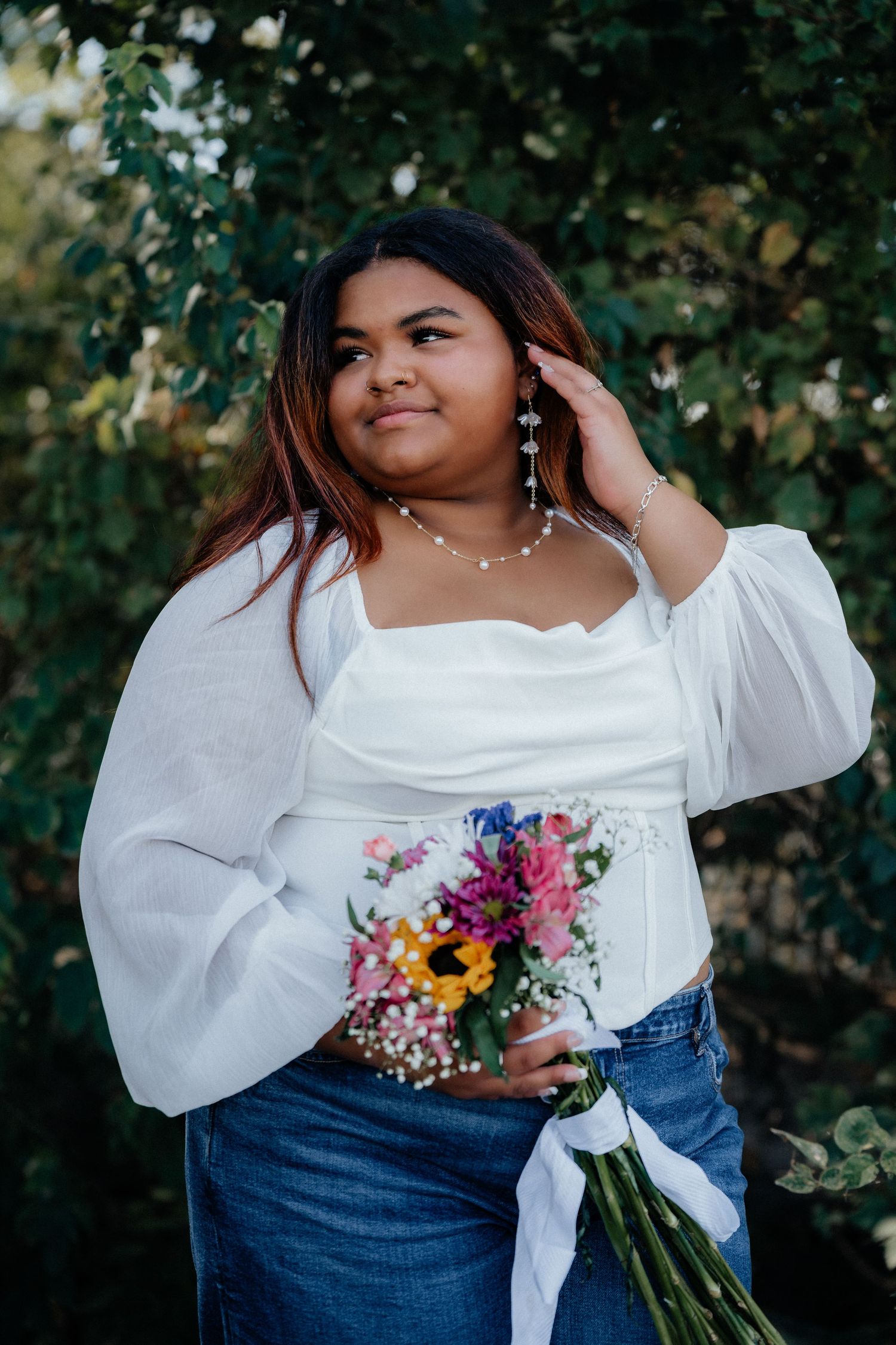 Summer fashion portrait with white blouse, denim and colorful floral bouquet. Marblehead Lighthouse Ohio