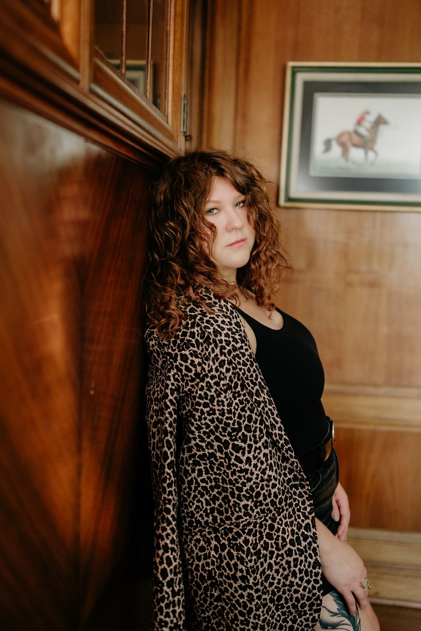 Stylish fashion portrait featuring leopard print and black clothing in a wood-paneled room. The christy house, fremont, ohio