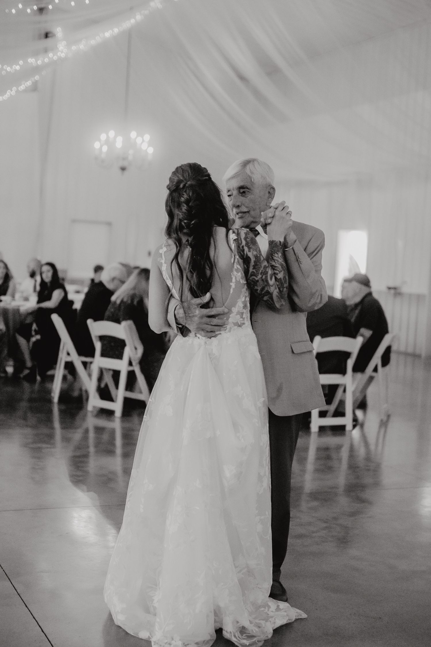 Black and white photos of a wedding couple dancing in a reception venue with string lights. Delta, Ohio wedding venue