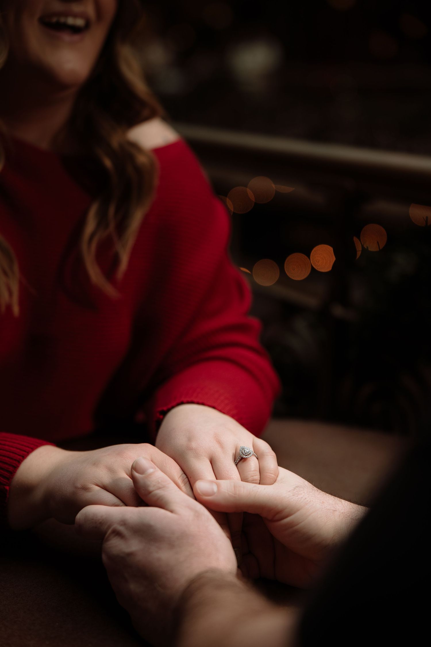 Intimate moment captured of hands touching with engagement ring visible in warm lighting. The arcade, Cleveland OHIO