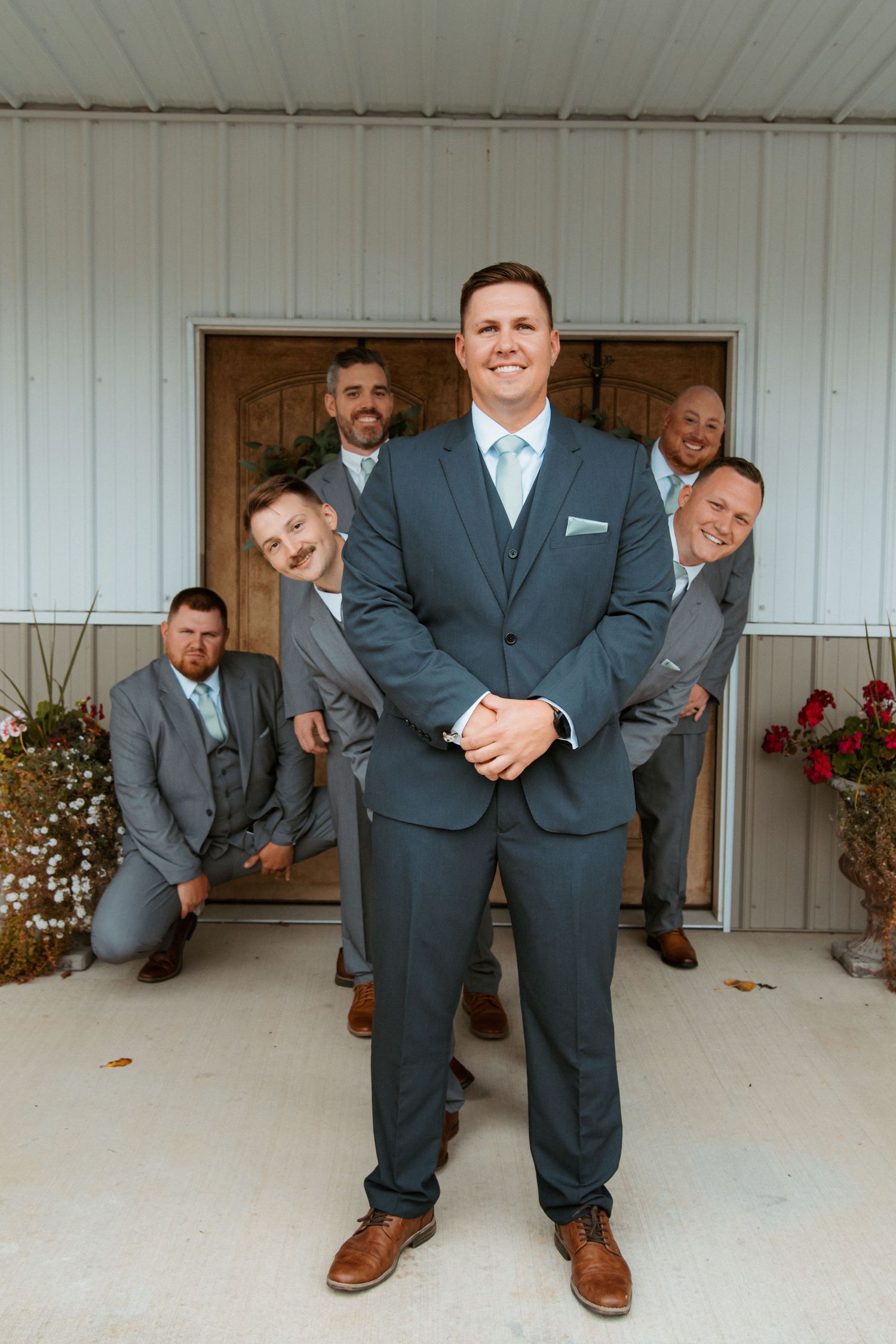 A fun groomsmen photo with the wedding party peeking around a doorway. Delta, Ohio wedding venue