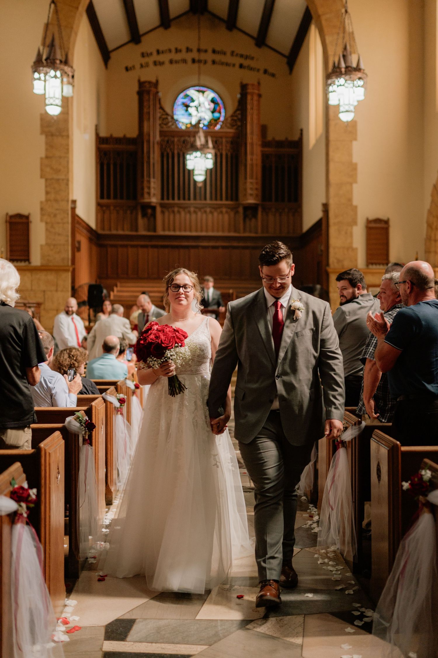 A joyful wedding recessional down the church aisle with guests looking on. Tiffin, Ohio Wedding Venue