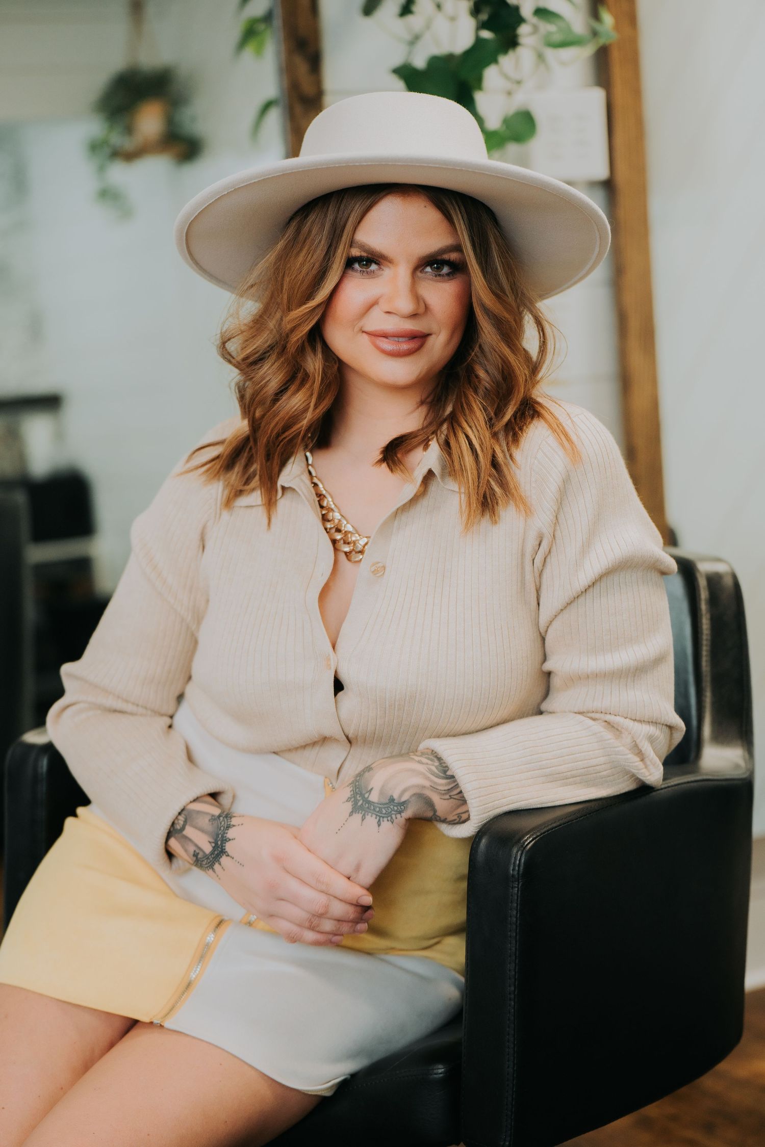 Fashion photos in a bright interior setting with cream-colored knitwear and accessories. Fremont, Ohio Hair Salon