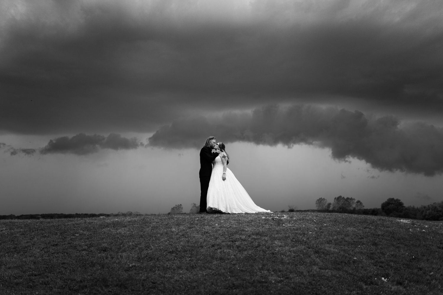 Dramatic panoramic wedding photo with stormy sky and rolling hills. Tiffin, Ohio Wedding Venue