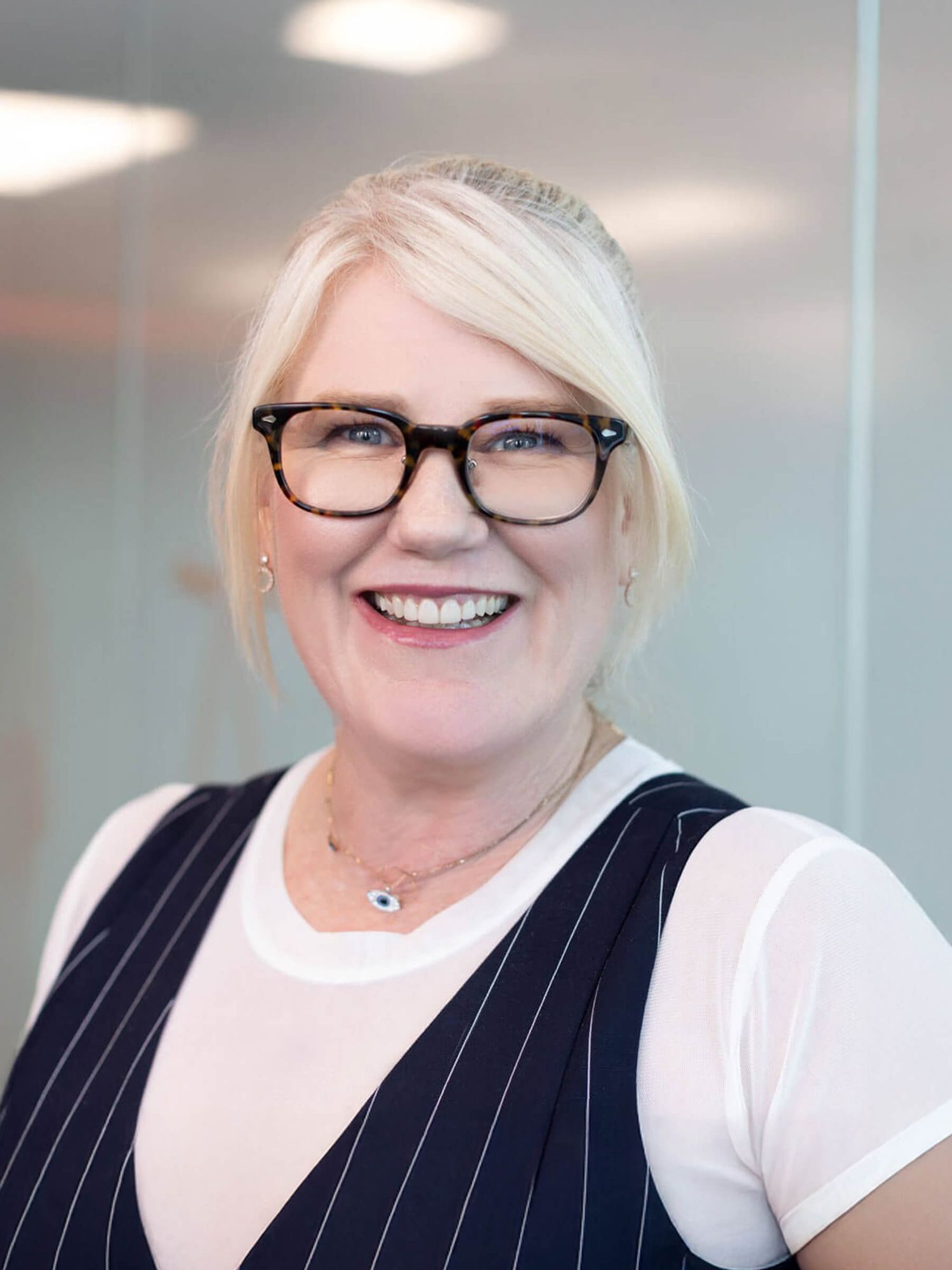 Professional headshot against a bright office background.