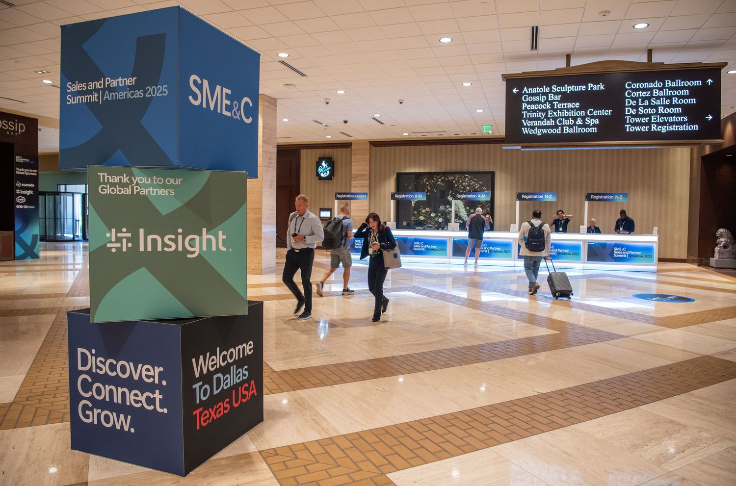 Modern conference center lobby with digital signage and directional markers.