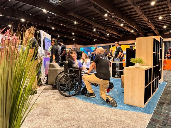 Technology conference exhibition hall with blue carpet and vendor booths.