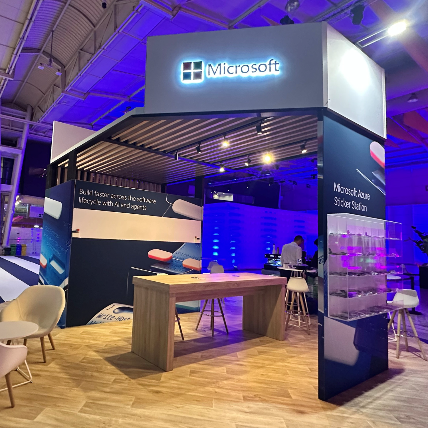 Microsoft event space with purple lighting, modern furniture and branded displays.