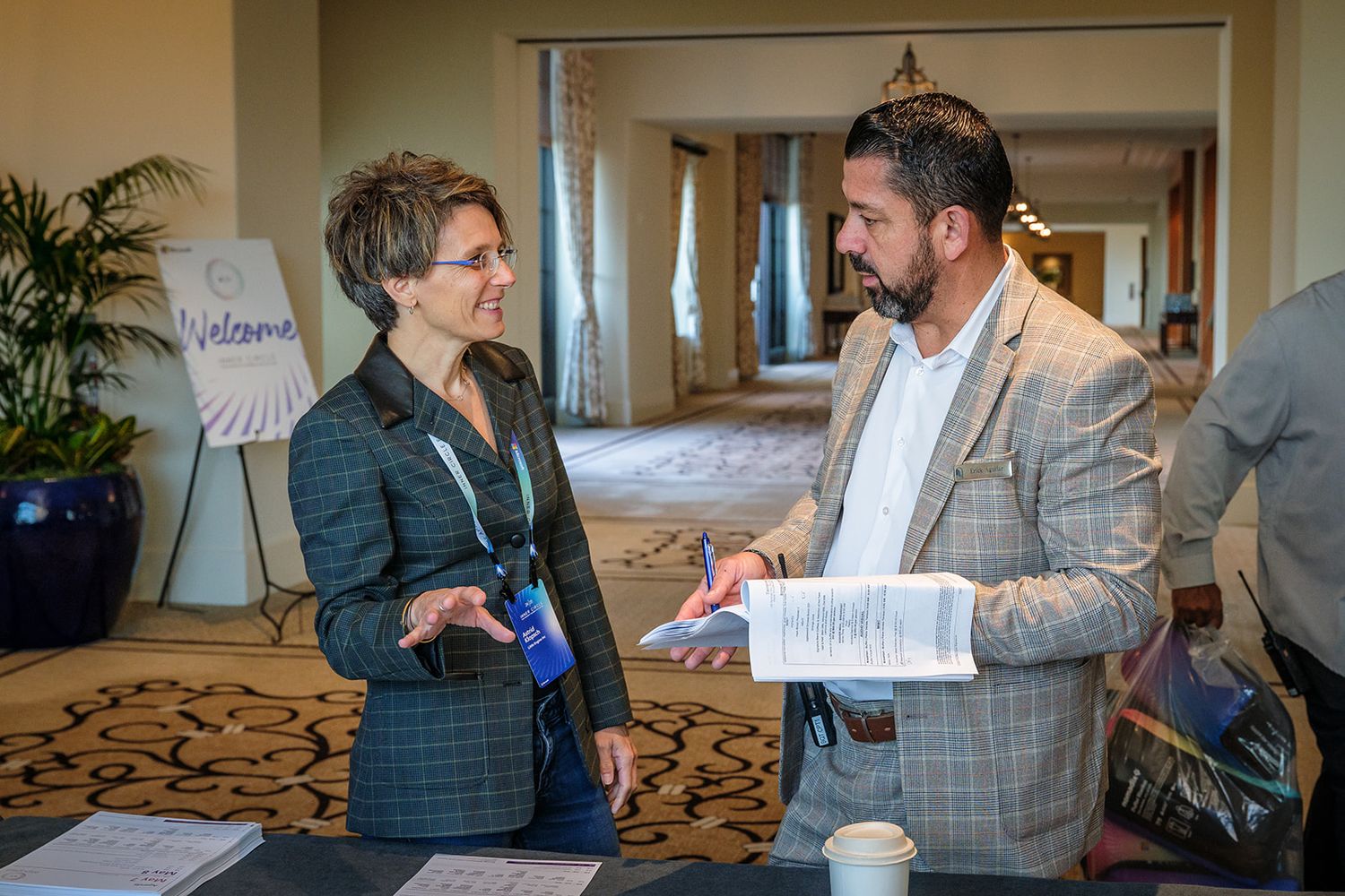 Two professionals having a business discussion in a hotel conference area.