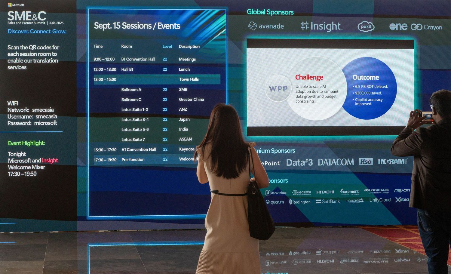 Large digital display screens showing business analytics and presentation slides in conference room.