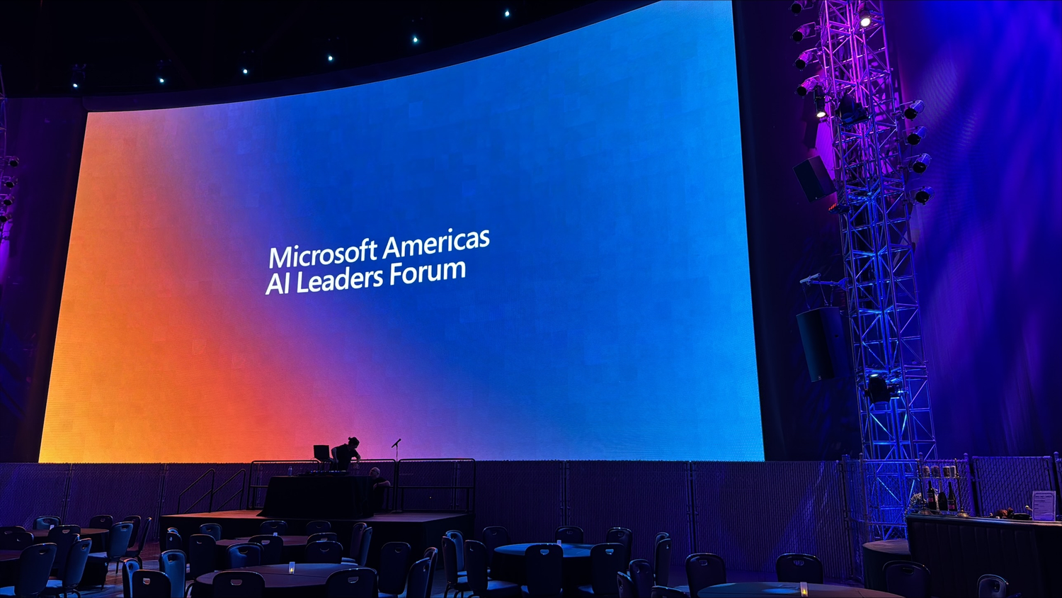 Large conference hall with blue and purple stage lighting for Microsoft AI Forum event.