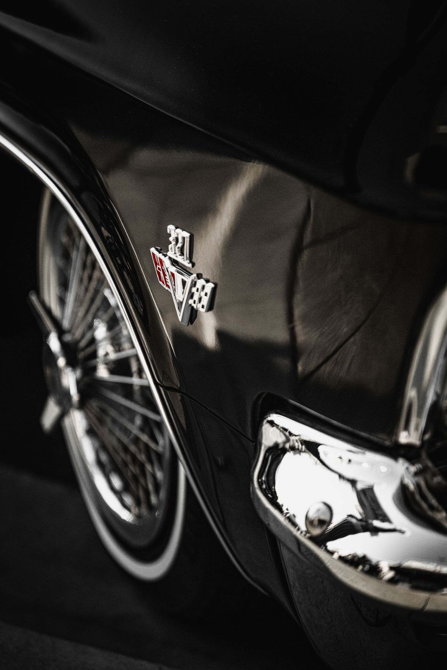 Close-up detail of vintage Chevrolet Impala badge and chrome trim.
