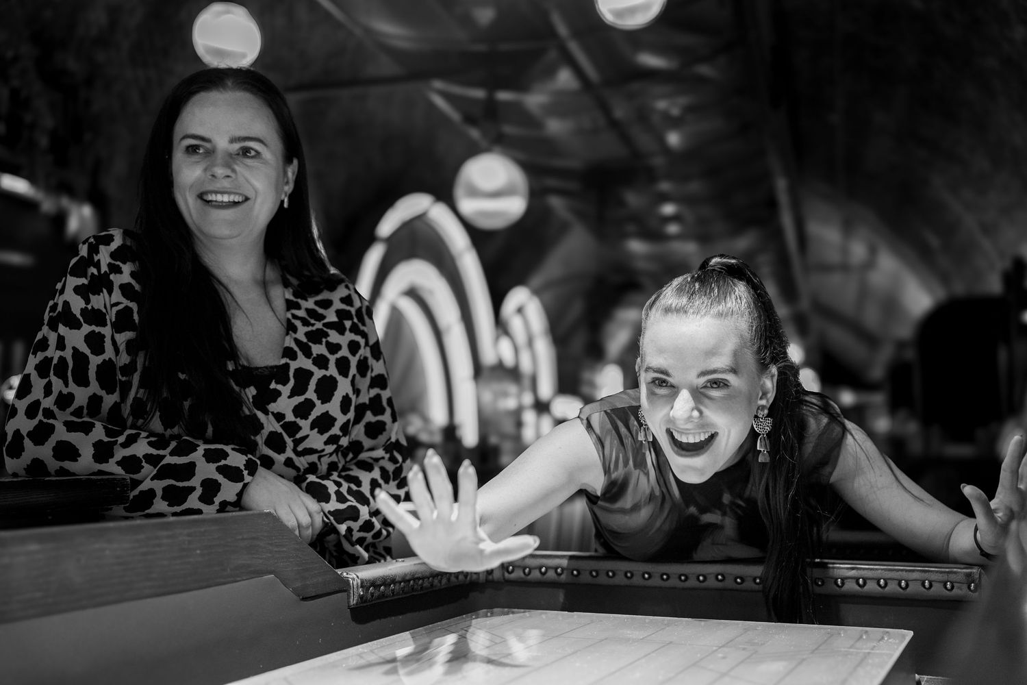 People enjoying a social gathering at a restaurant with laughter and smiles around a table.