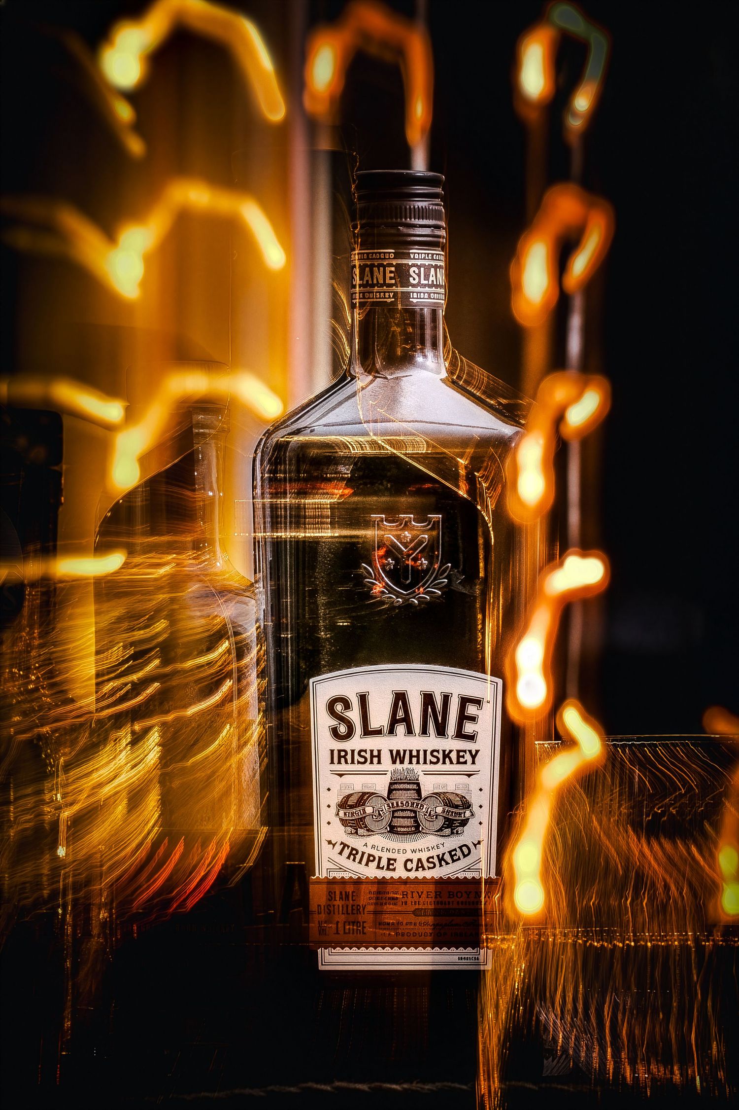 Slane Irish Whiskey bottle photographed with dramatic light trails and golden bokeh effects creating an artistic composition.