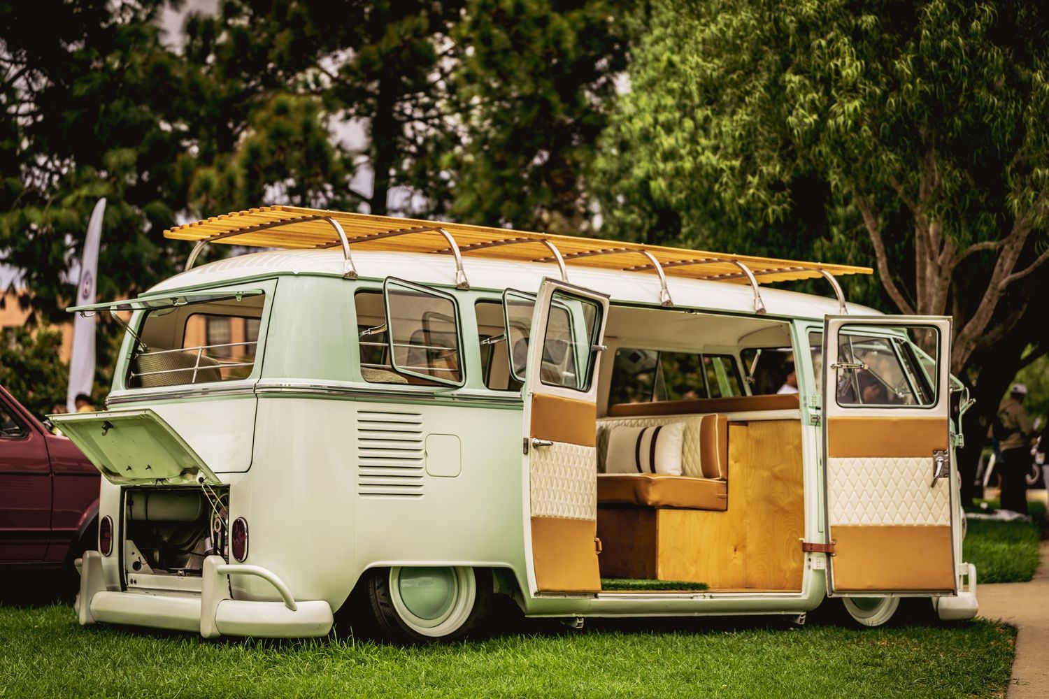 A collection of vintage travel trailers and campers parked in a row at a campground.