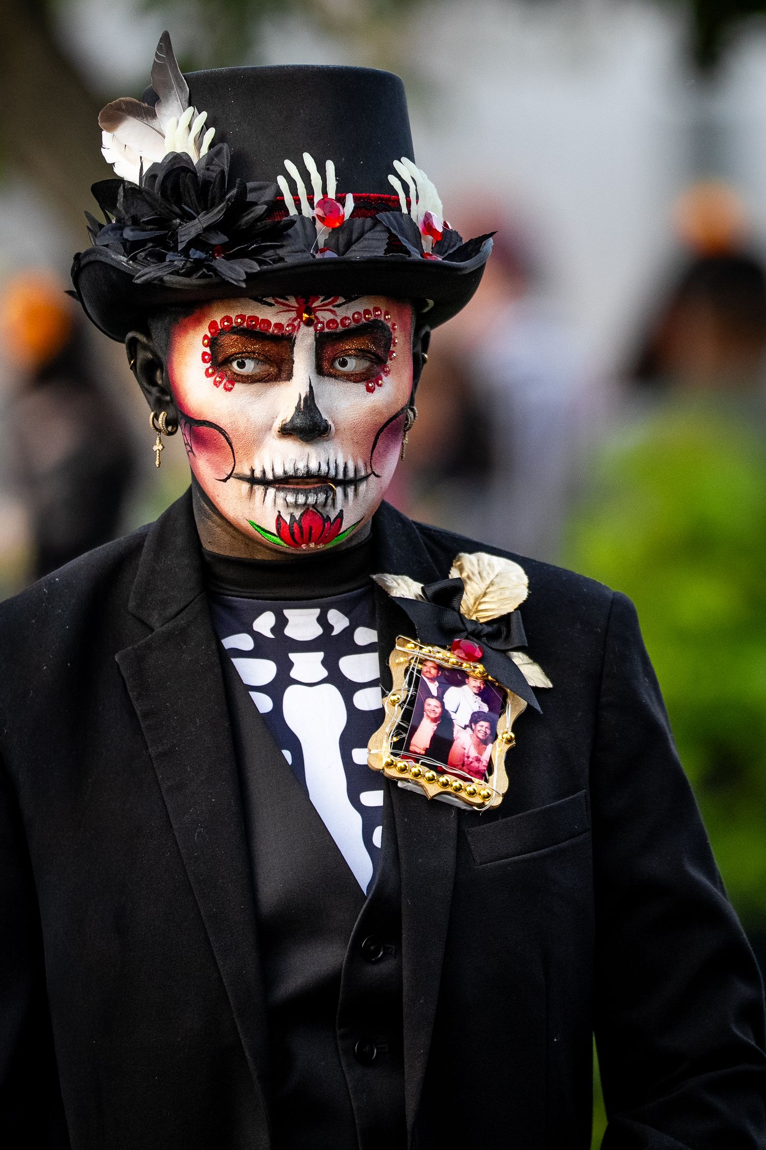 Day of the Dead performers in black suits with skeleton face paint and decorative accessories.