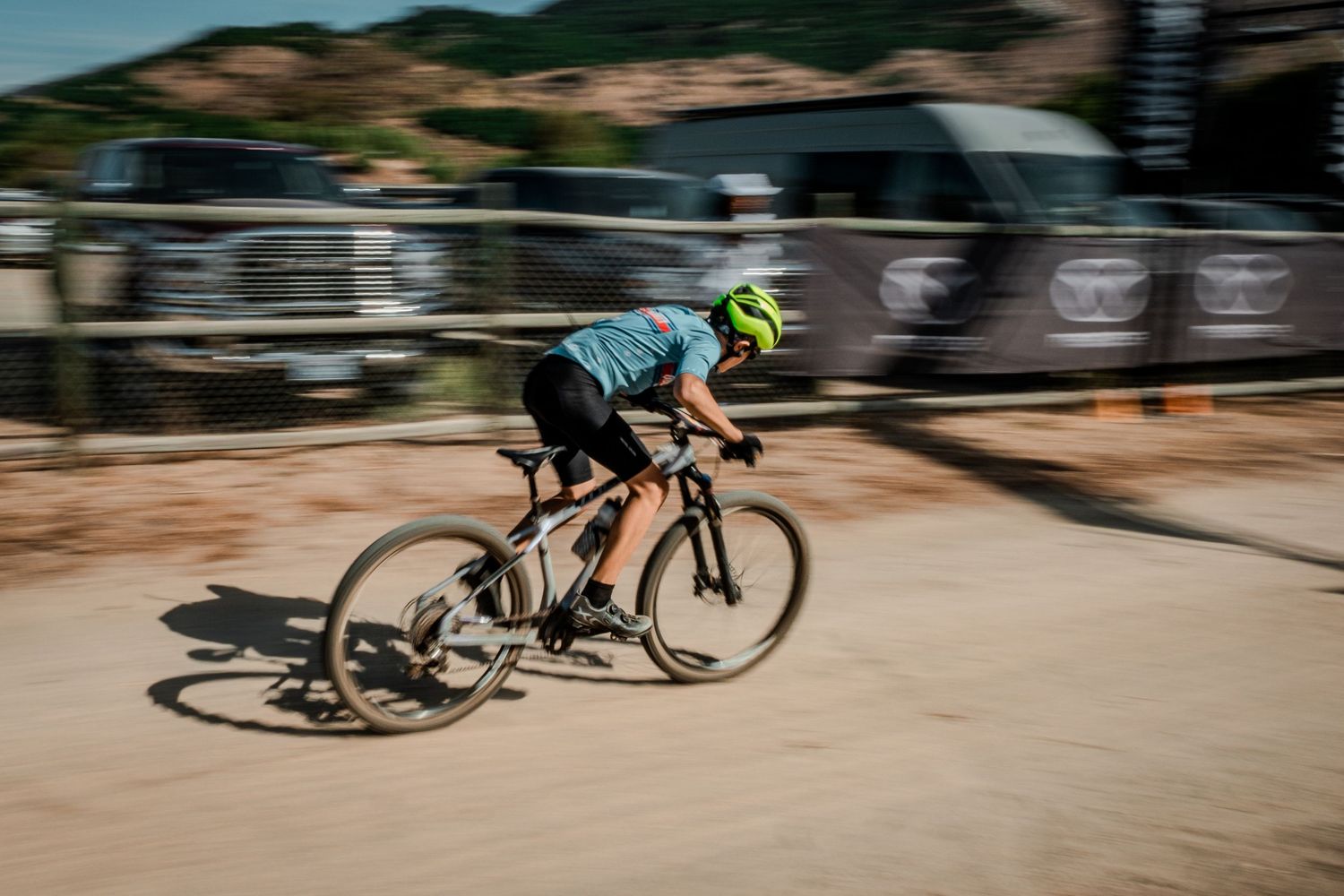 Motion blur of cyclists racing on a dirt track during a competition.