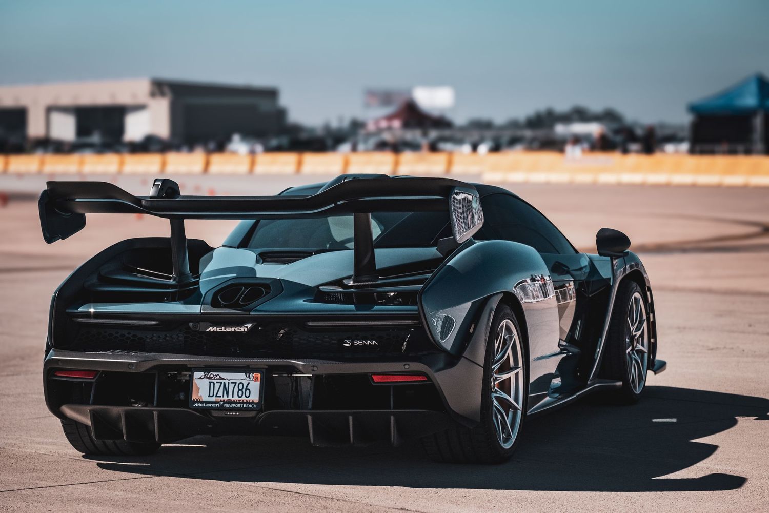 Sleek sports cars displayed at an automotive show with dramatic lighting.