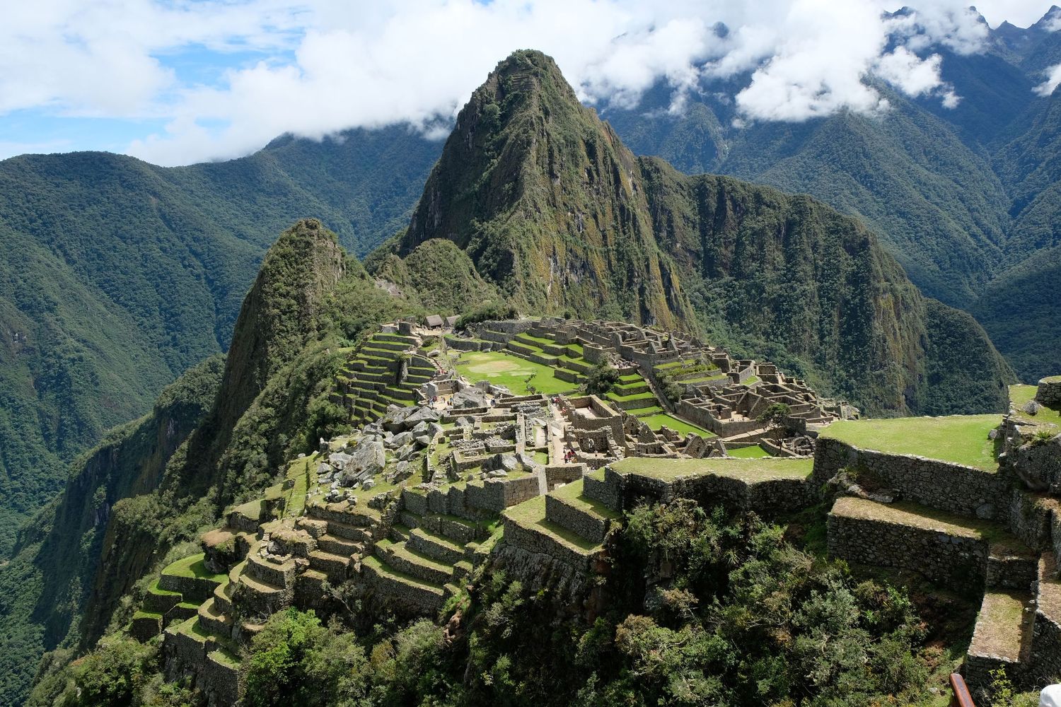 Panoramic view of Machu Picchu's terraced ruins nestled among misty mountain peaks.