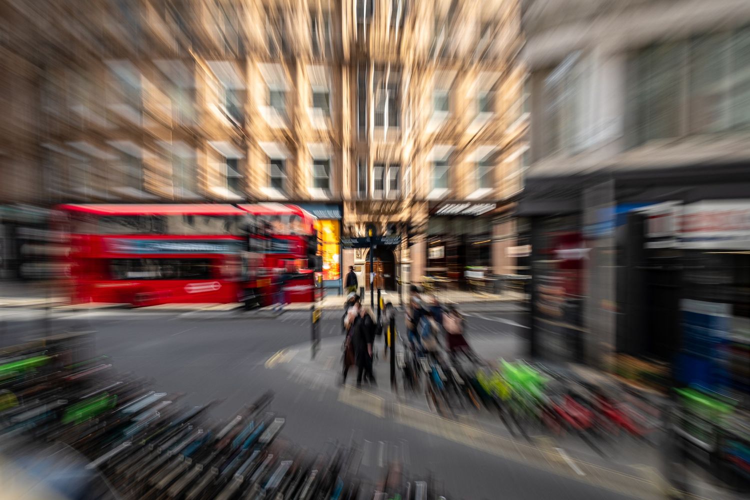 Motion blur cityscape with red double decker bus creating dynamic streaks through urban streets of London.