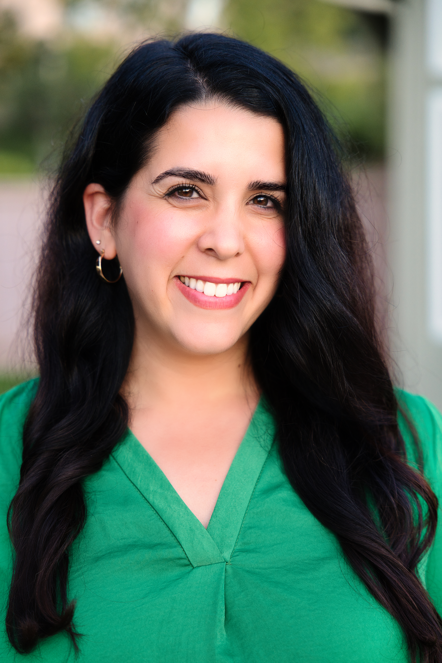 Professional headshots featuring bright green attire against a soft background.