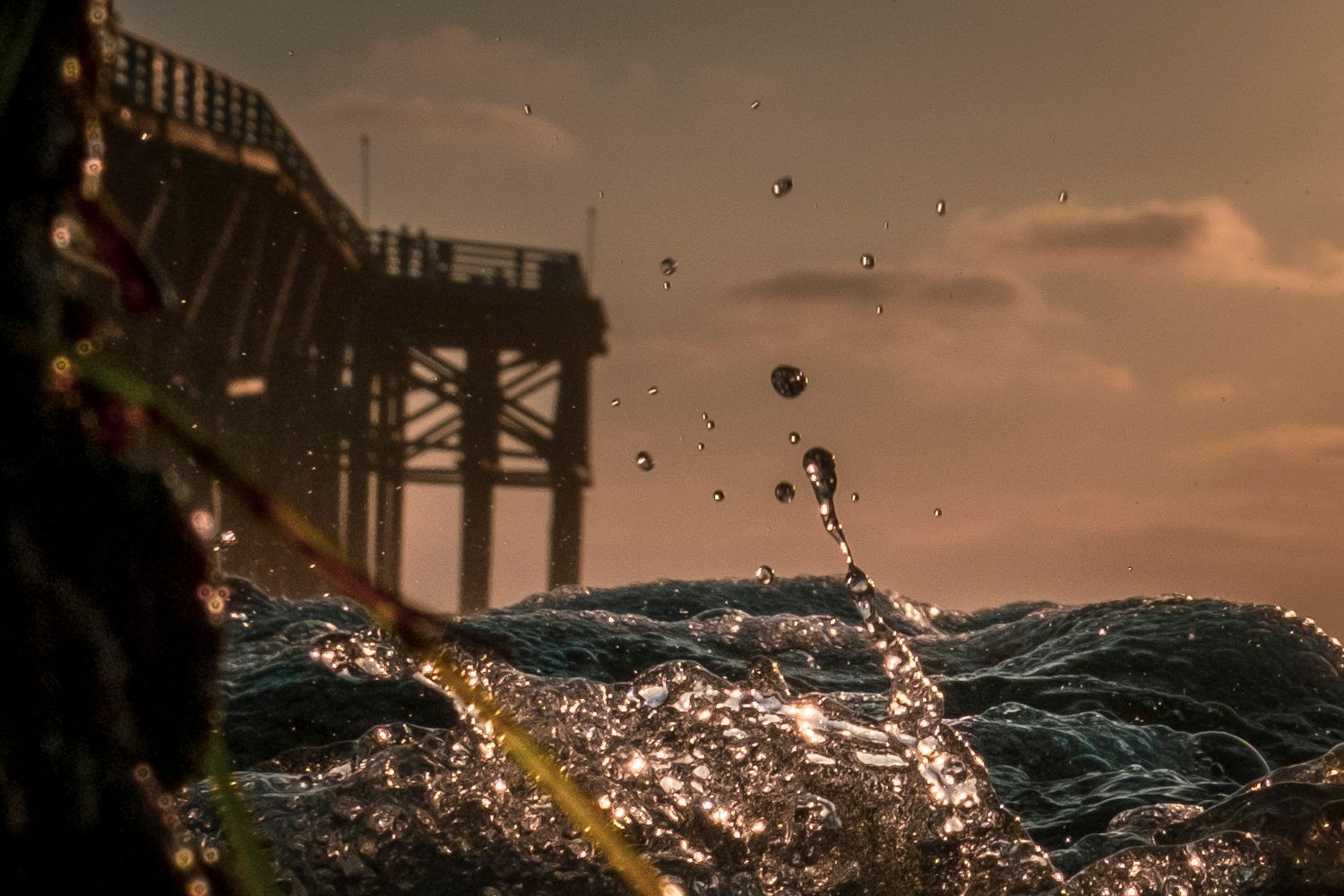 Water splashing in dramatic slow motion against dark background at sunset.