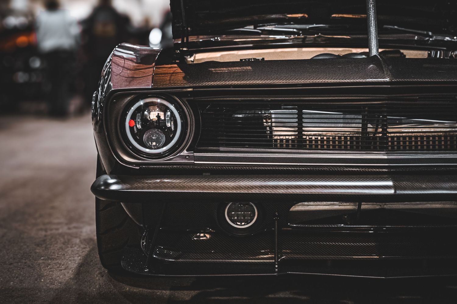 Close-up detail shot of a classic car's chrome headlight and grille.
