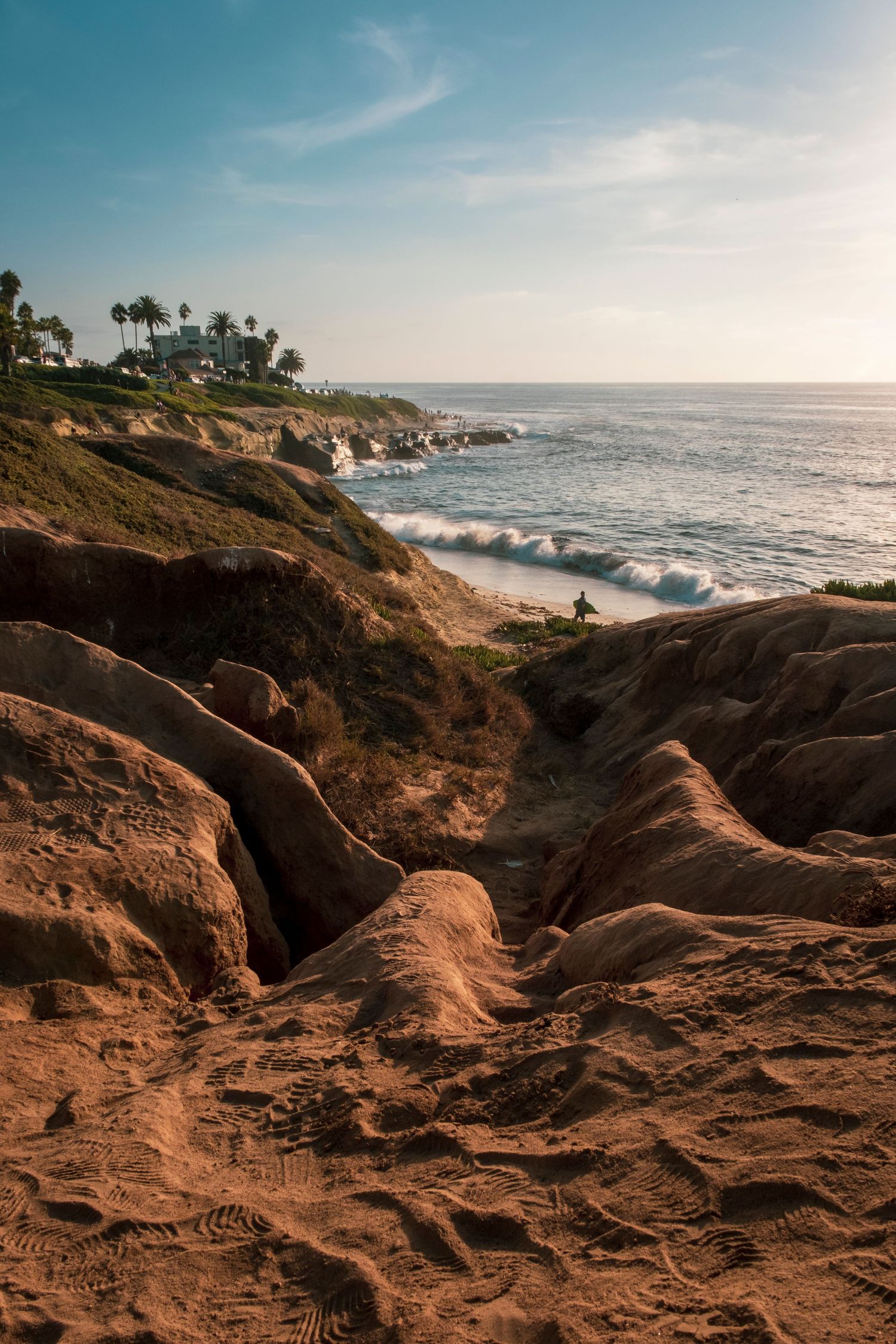 Coastal landscape with rocky cliffs and ocean waves during golden hour.