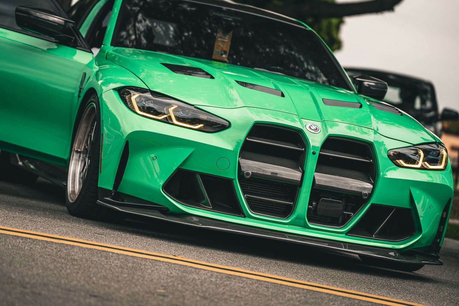 Bright green BMW M4 sports car shown from multiple low angles on a street.